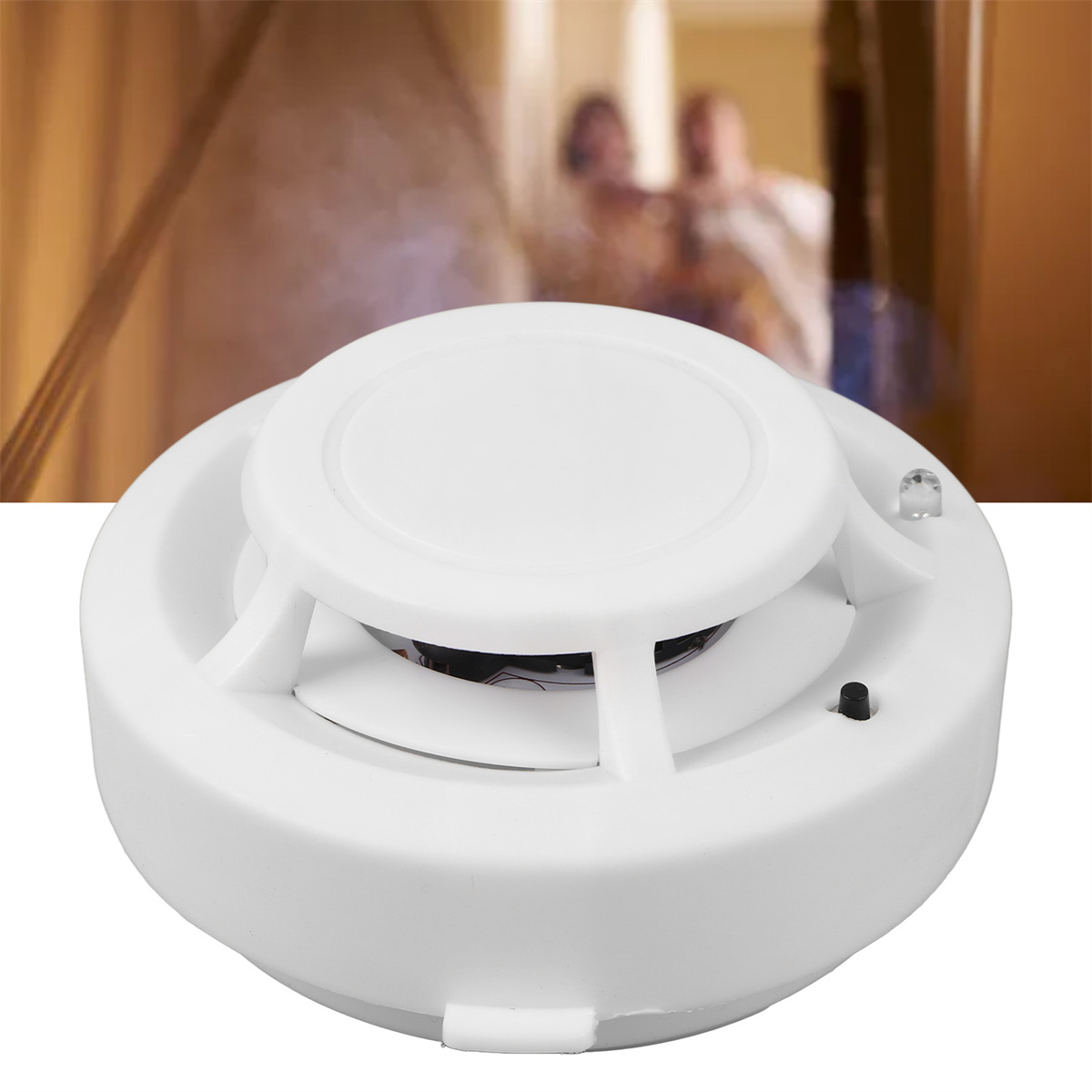 Ein weißer Rauchmelder, mit einem schwarzen Sensor in der Mitte, drinnen, Nahaufnahme.