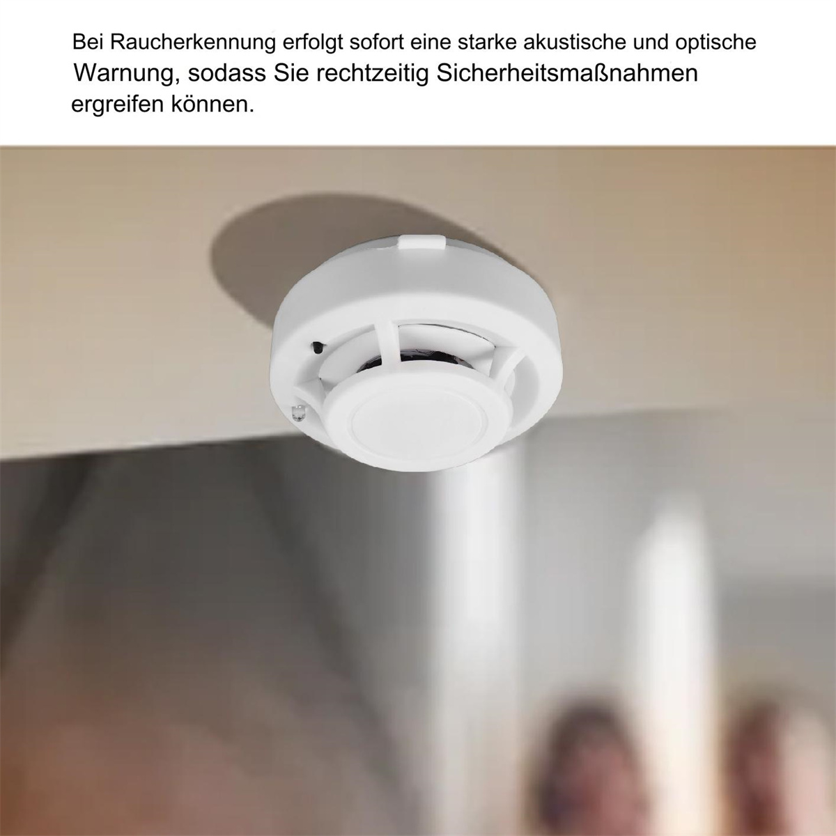 Weißer Rauchmelder an der Decke montiert, mit deutschem Text darüber.