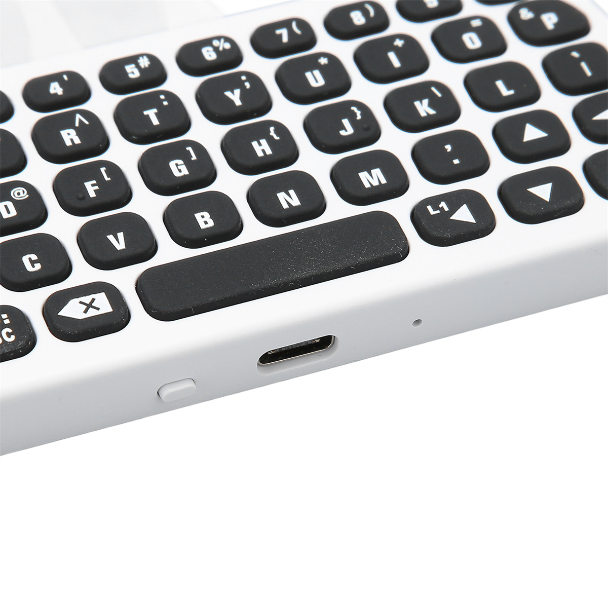 Nahaufnahme einer weißen Tastatur mit schwarzen Tasten, mit Buchstaben und Symbolen.