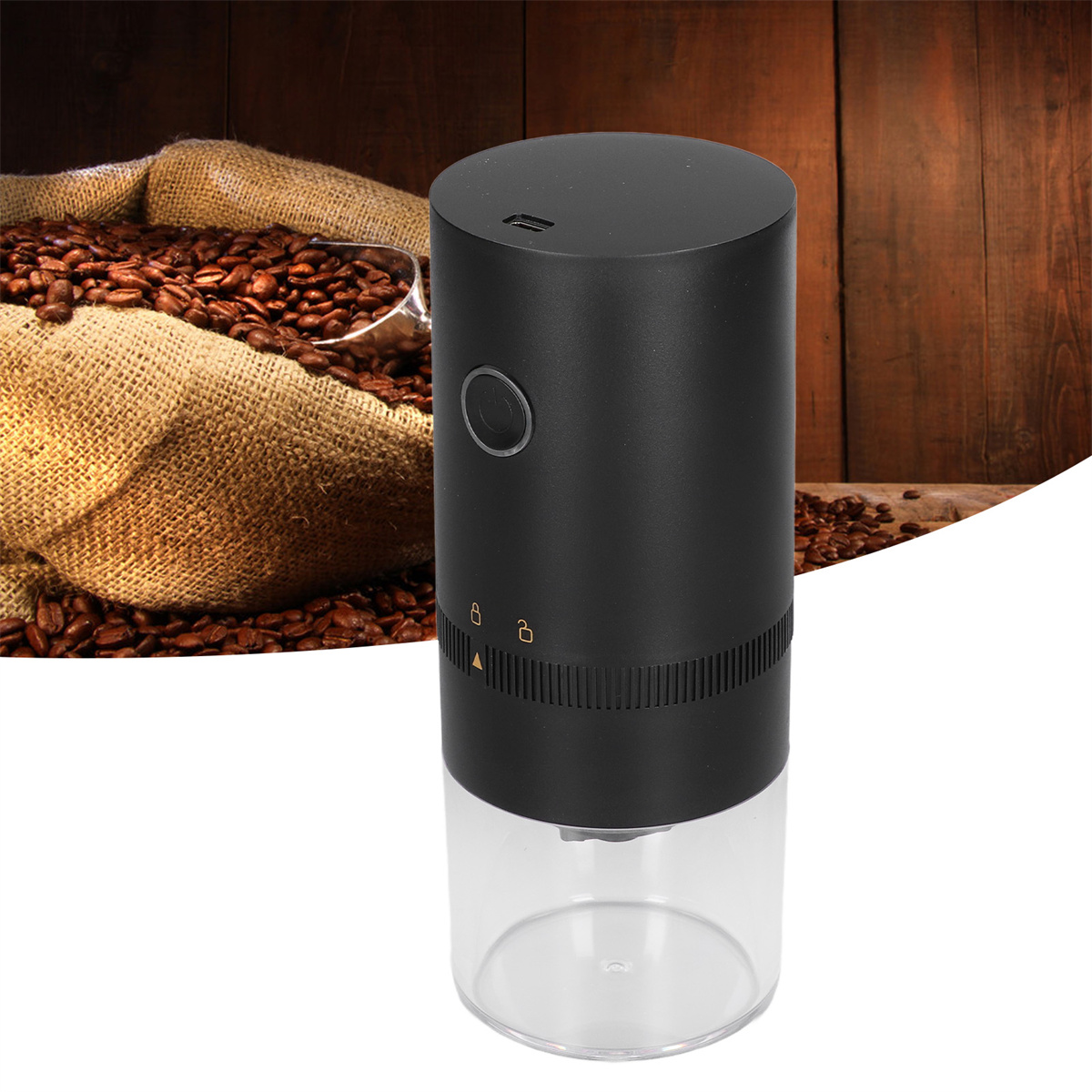 Schwarze Kaffeemühle mit durchsichtigem Boden, Bohnen im Hintergrund auf Holz.