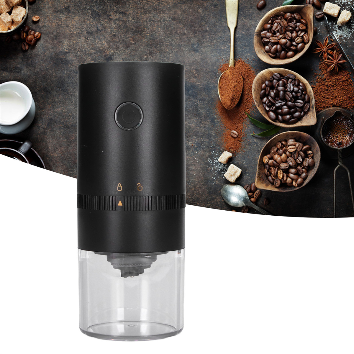 Schwarze Kaffeemühle mit transparentem Boden, neben Kaffeebohnen, Pulver und Löffel.