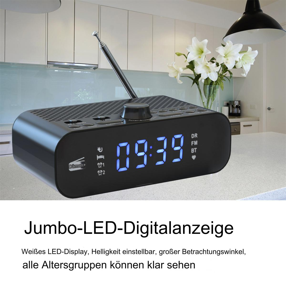 Schwarzes Digitaluhrradio mit blauem Display und eine weiße Blumenvase.