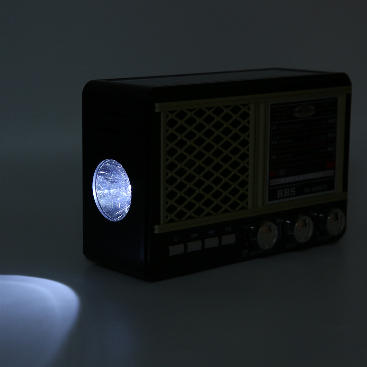 Schwarzes Vintage-Radio mit einer Taschenlampe. Die Taschenlampe ist eingeschaltet, leuchtet.