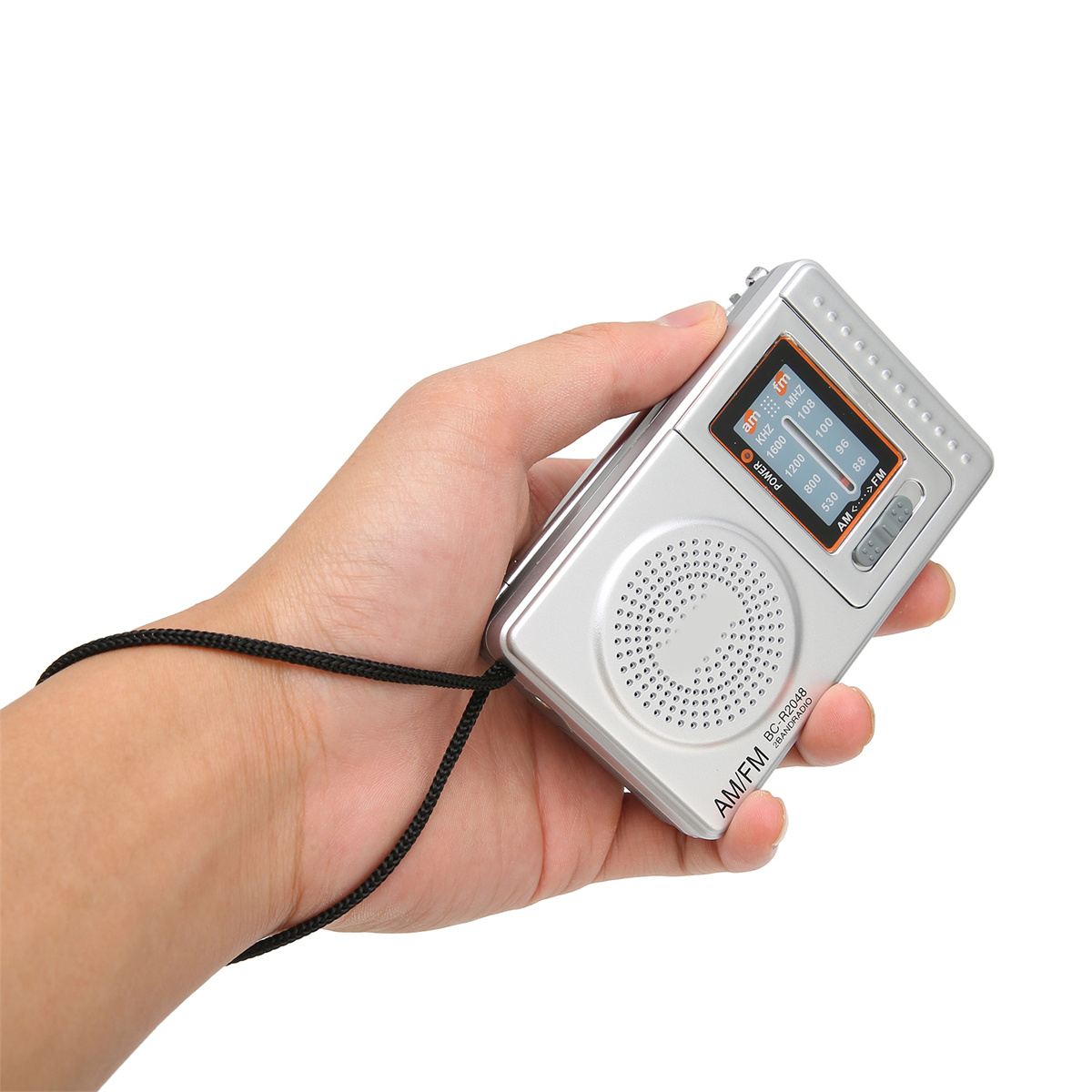 Eine Person hält ein silbernes Radio im Retro-Stil mit einem Drehrad und AM/FM.