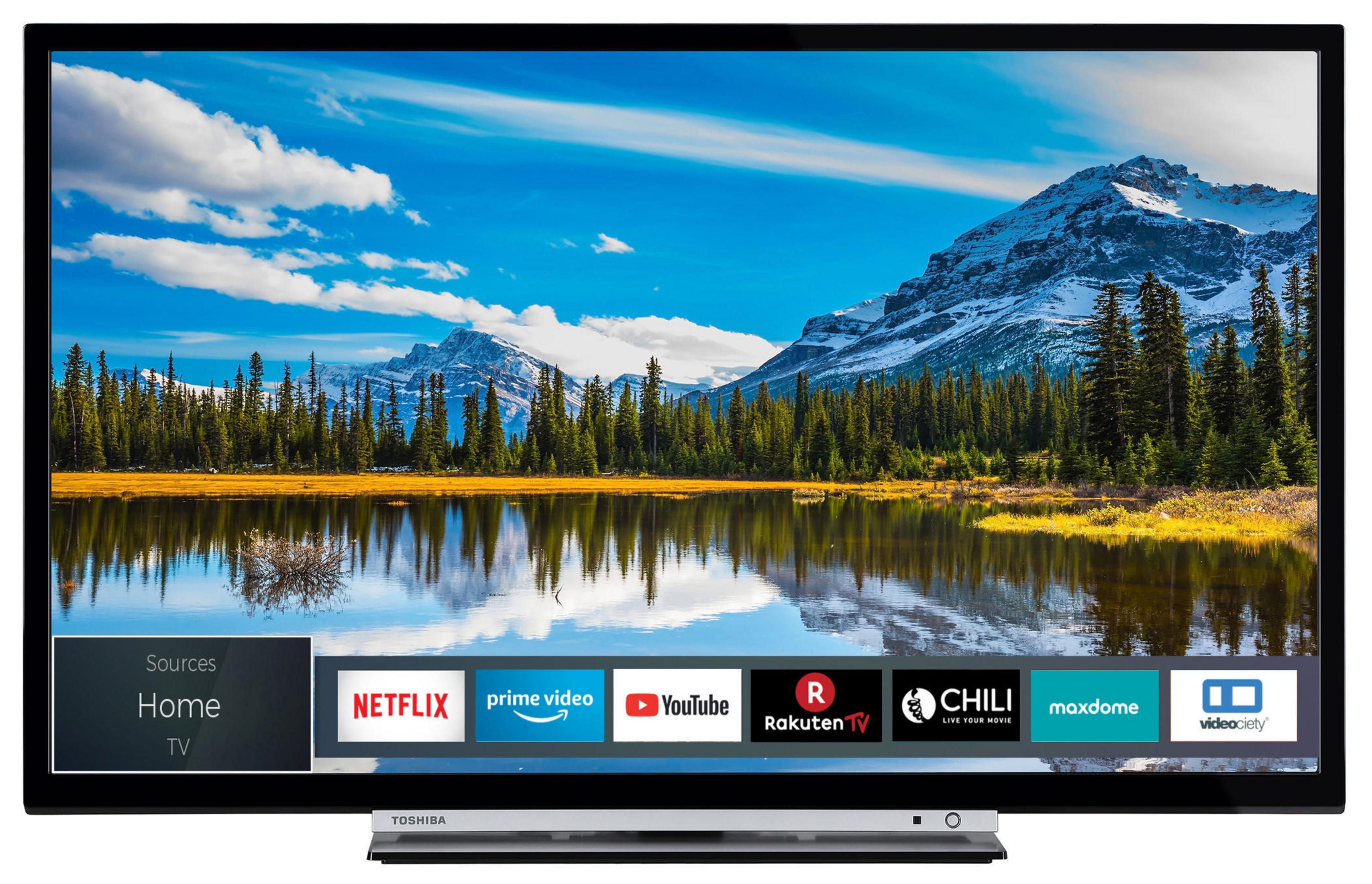 Una TV nera che mostra un paesaggio con lago, montagne e cielo blu con nuvole.