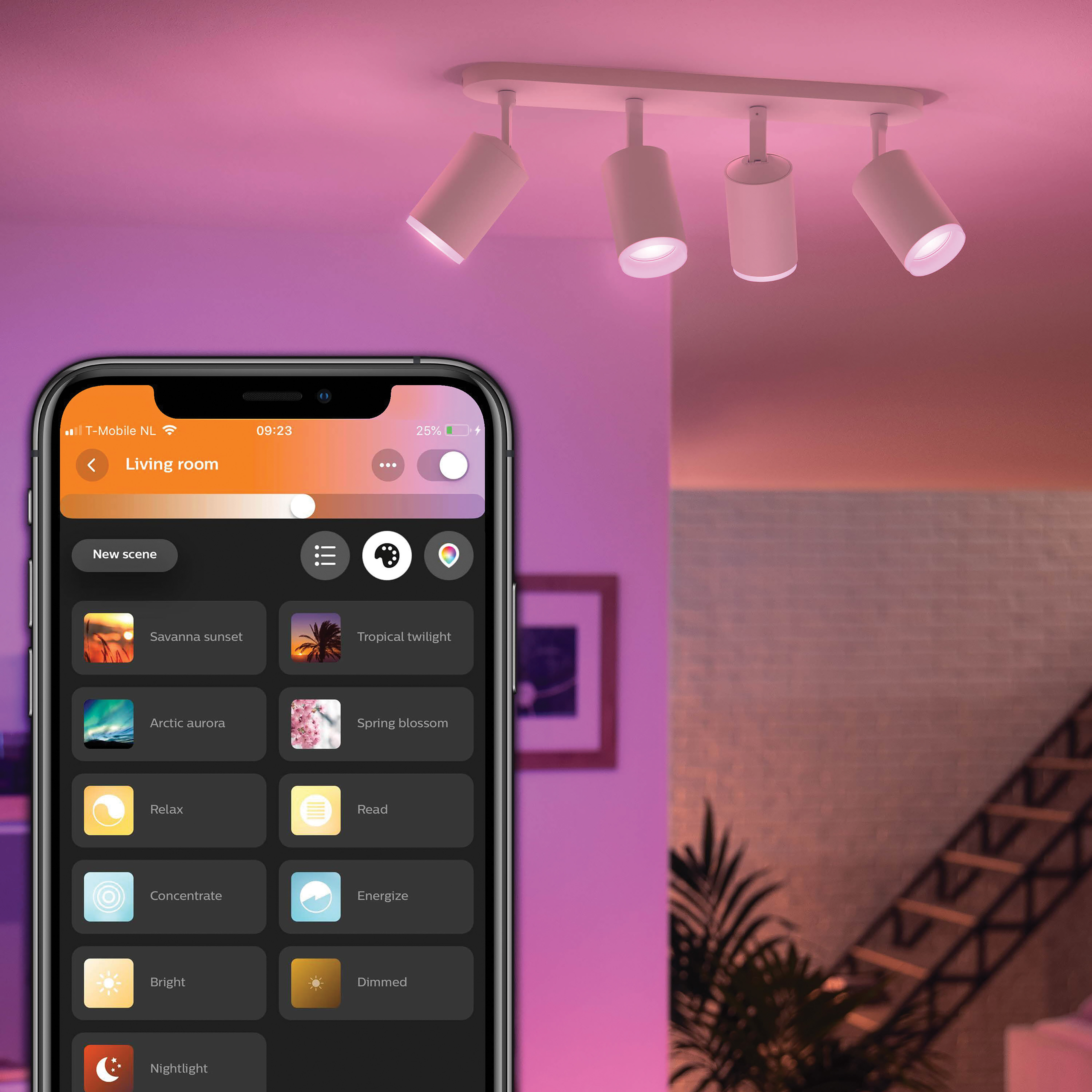 Un smartphone contrôle un système d'éclairage sur rail, avec des lumières de différentes couleurs.
