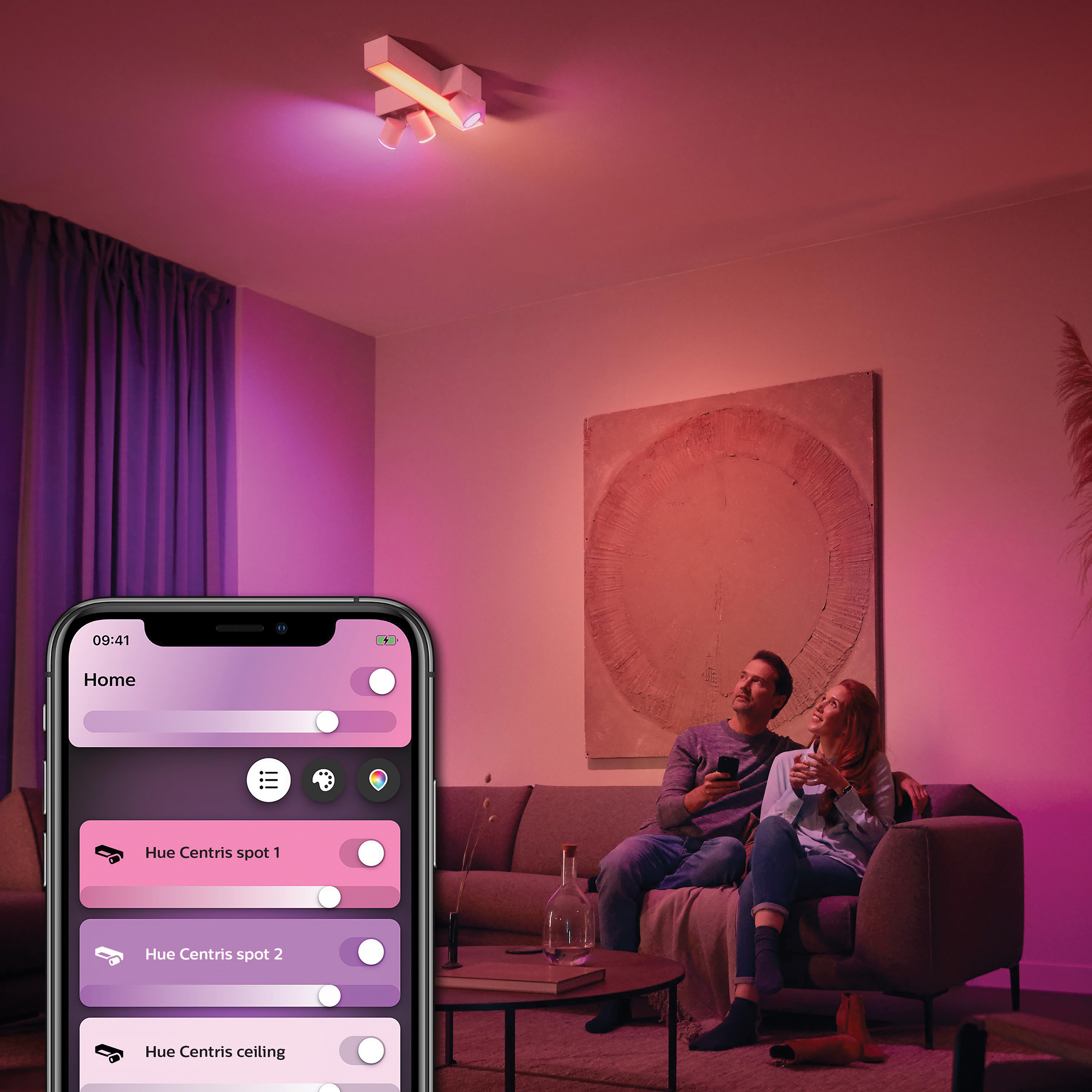 Koppel dat Philips Hue-lampen gebruikt in een woonkamer, bestuurd door een smartphone.