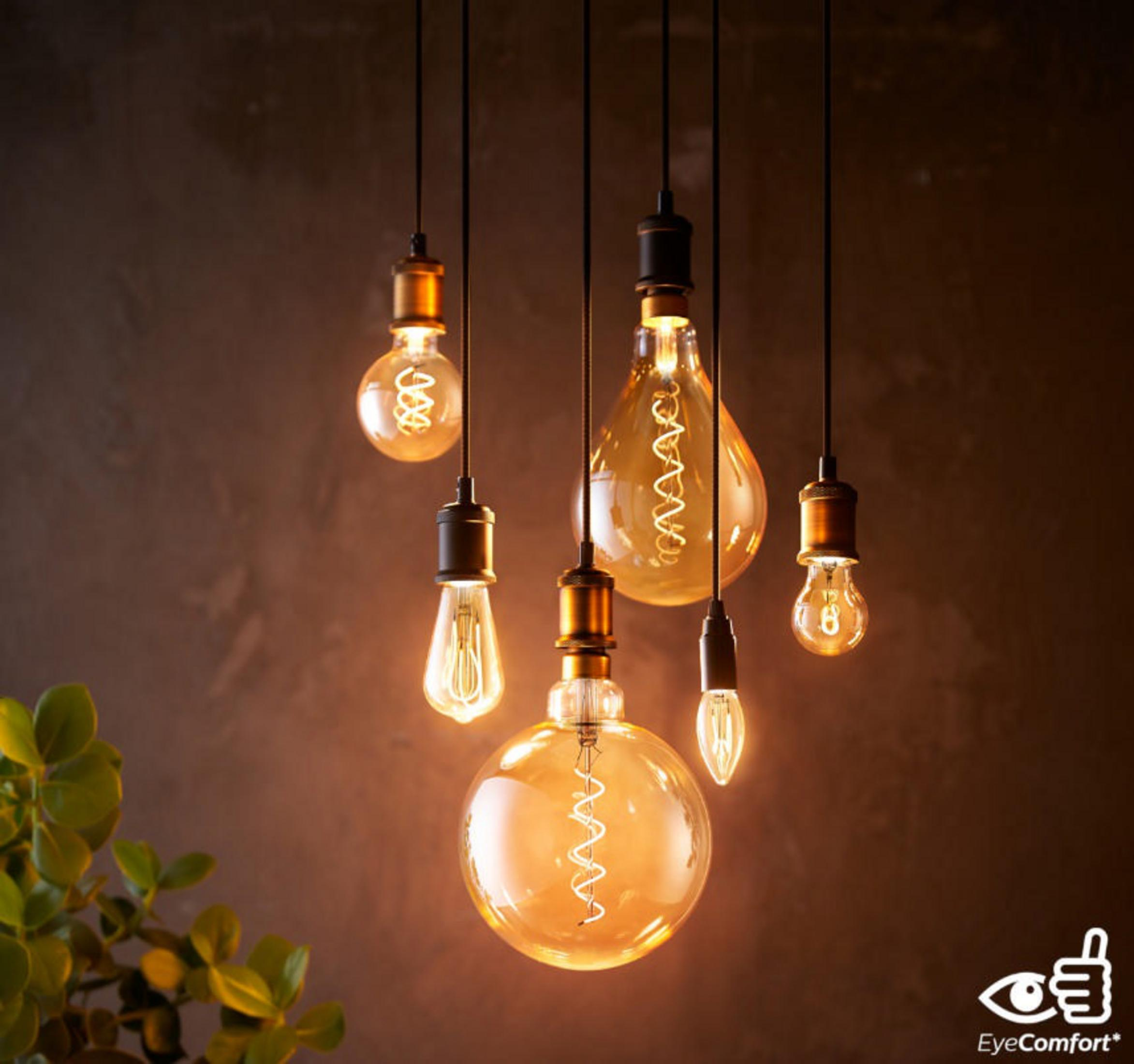 Meerdere Edison-stijl lampen hangen. Ze hebben goudgele gloeidraden, verlicht in een donkere kamer.