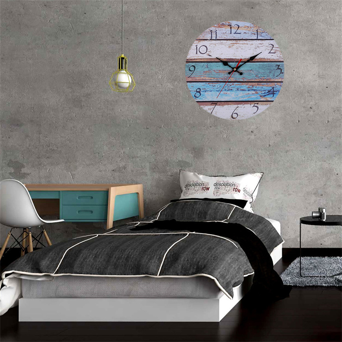 Schlafzimmer: eine Holzuhr an einer grauen Wand, Bett mit schwarzer Decke, Schreibtisch und Stuhl.