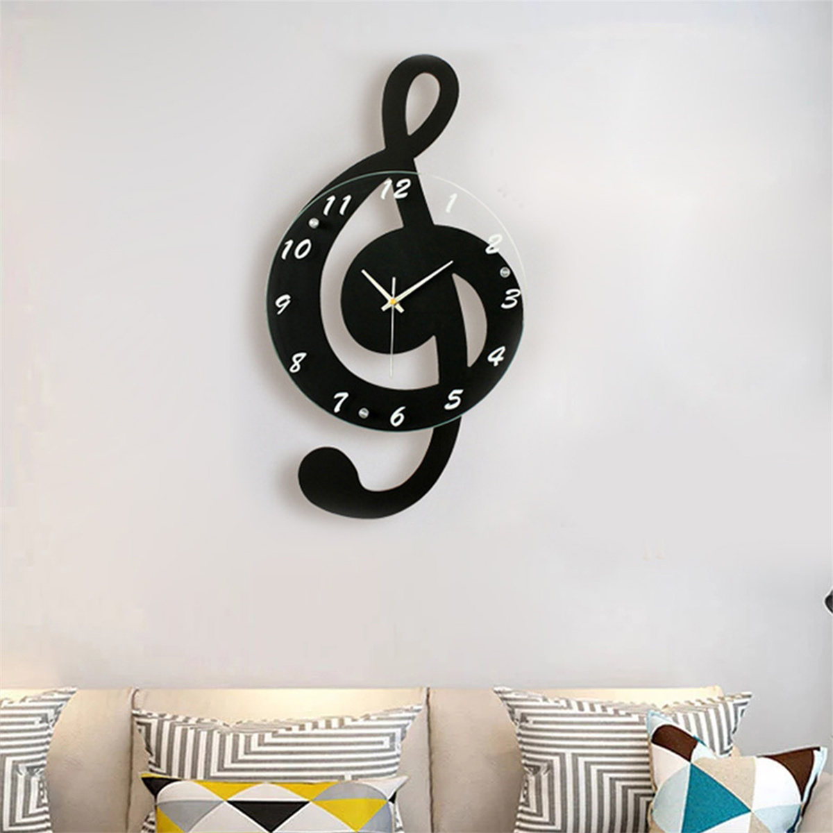 Schwarze Notenschlüssel-Uhr an einer weißen Wand. Weiße Zahlen und Zeiger.