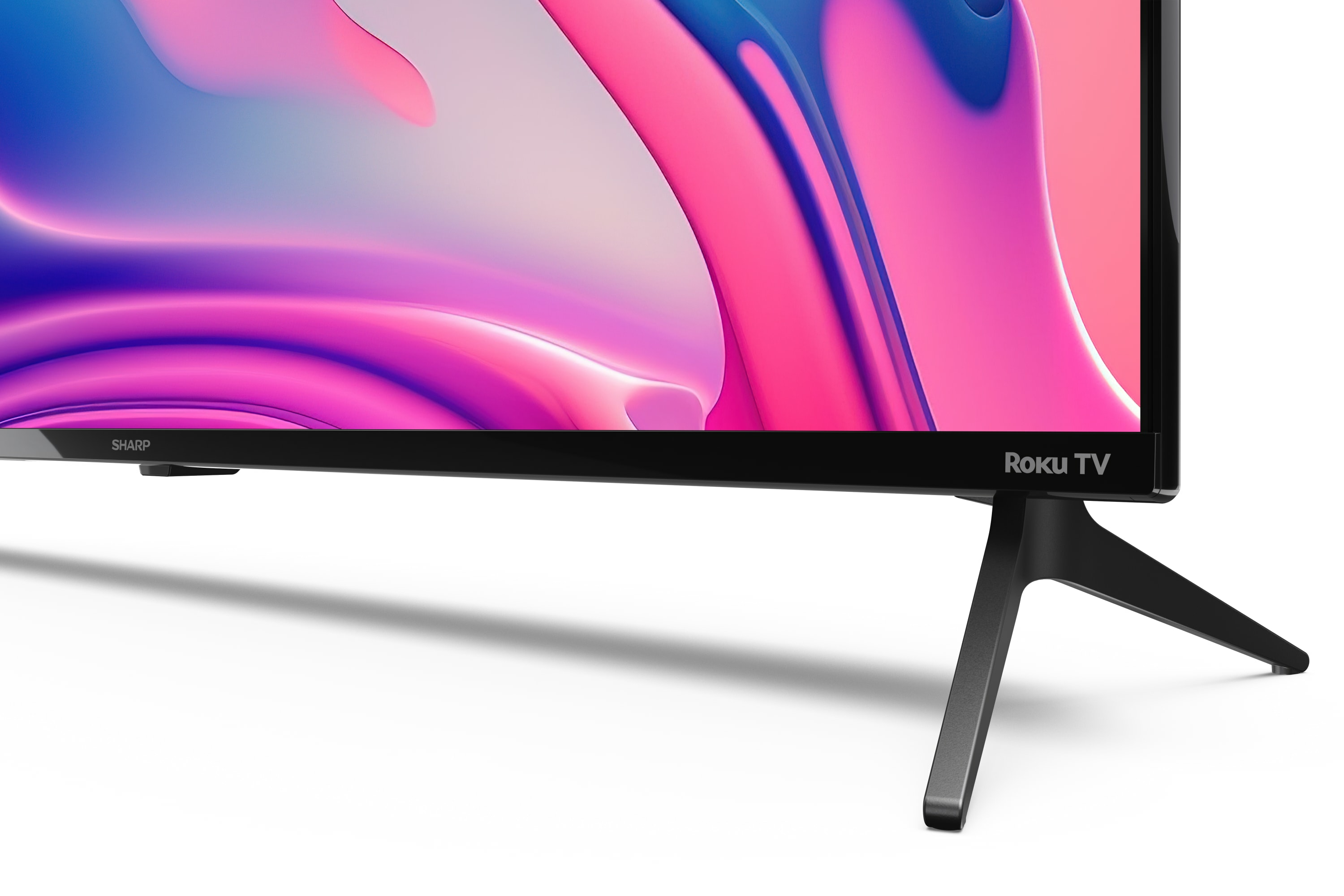 Roku TV, schwarzer Ständer und ein farbenfroher, abstrakter Hintergrund.