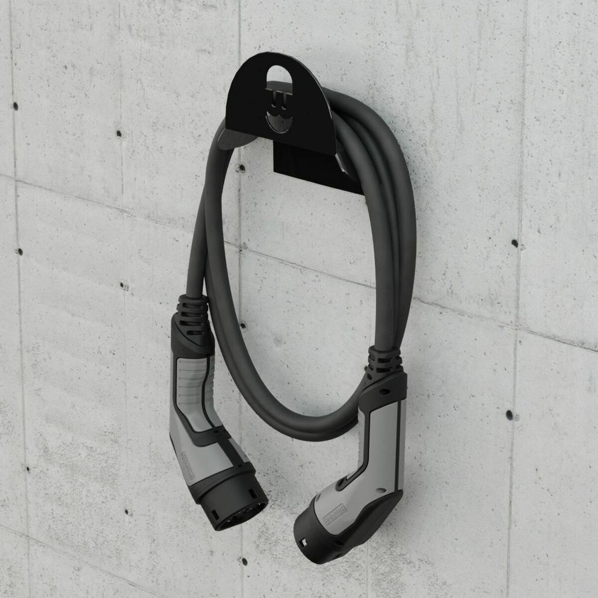 Ein Ladekabel für Elektrofahrzeuge, das an einer Betonwand mit einem schwarzen Halter befestigt ist.