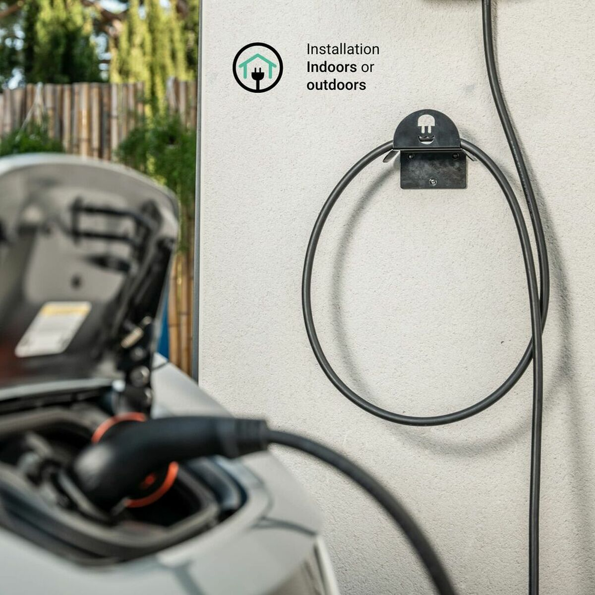 Ladekabel an der Wand. Das Bild zeigt ein Ladegerät mit einem EV-Auto im Bild.