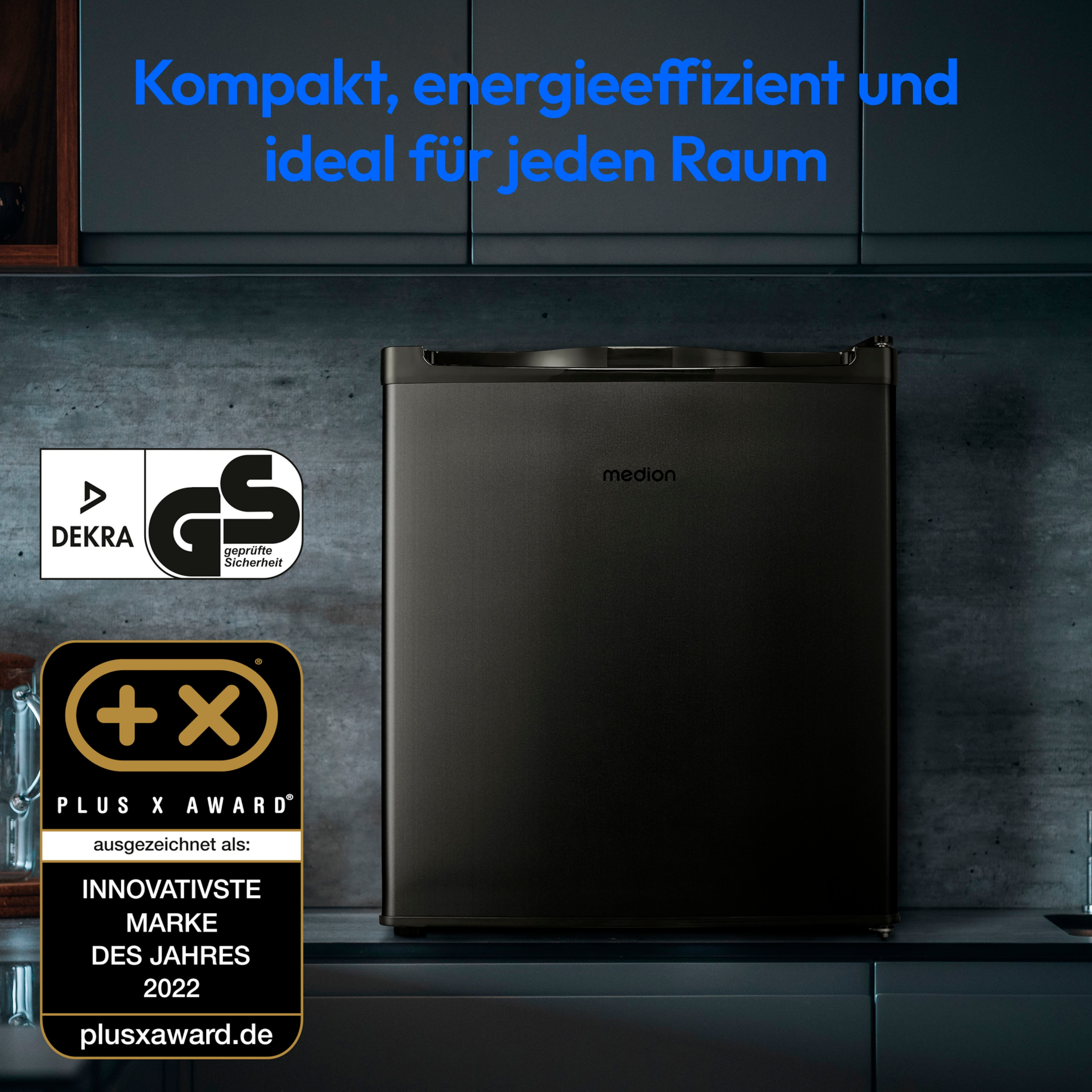 Czarna mini-lodówka z logo i nagrodami. Tekst: kompaktowa, energooszczędna, idealna do każdego pomieszczenia.