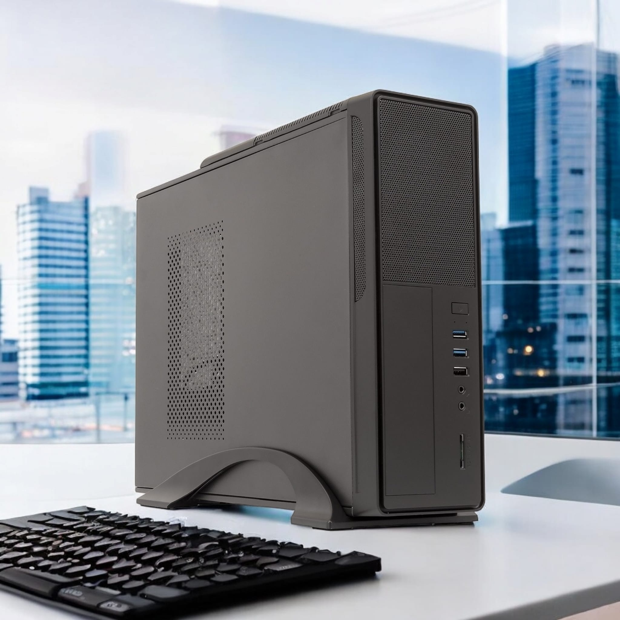Una pequeña computadora negra en un soporte junto a un teclado, con un horizonte de la ciudad visible.