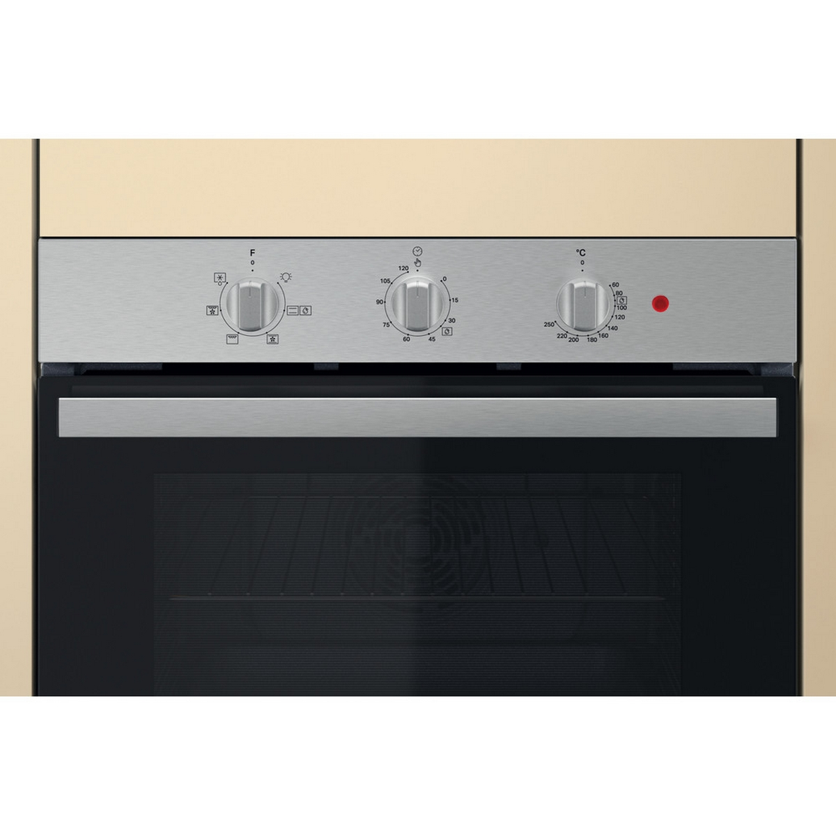 Primo piano del pannello di controllo del forno con manopole e luce rossa, circondato da un mobile beige.