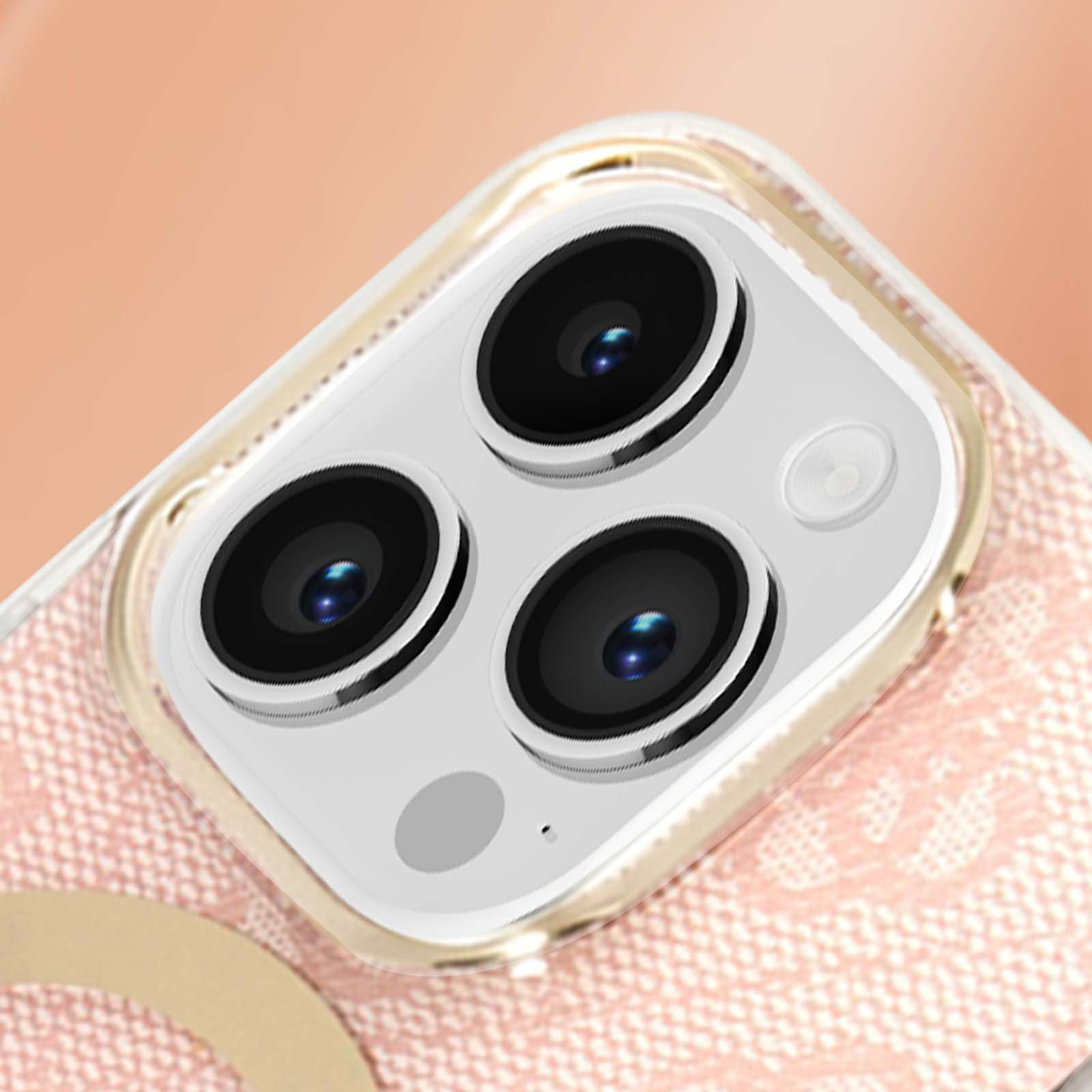 Primo piano del modulo fotocamera di un telefono con tre obiettivi e un flash su sfondo rosa a fantasia.