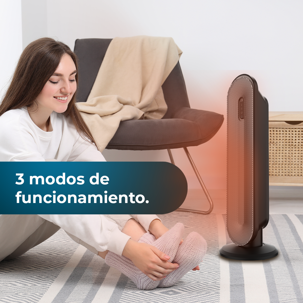 Mujer sentada, sonriendo a un calefactor negro. Calcetines rosas, silla gris, manta beige.