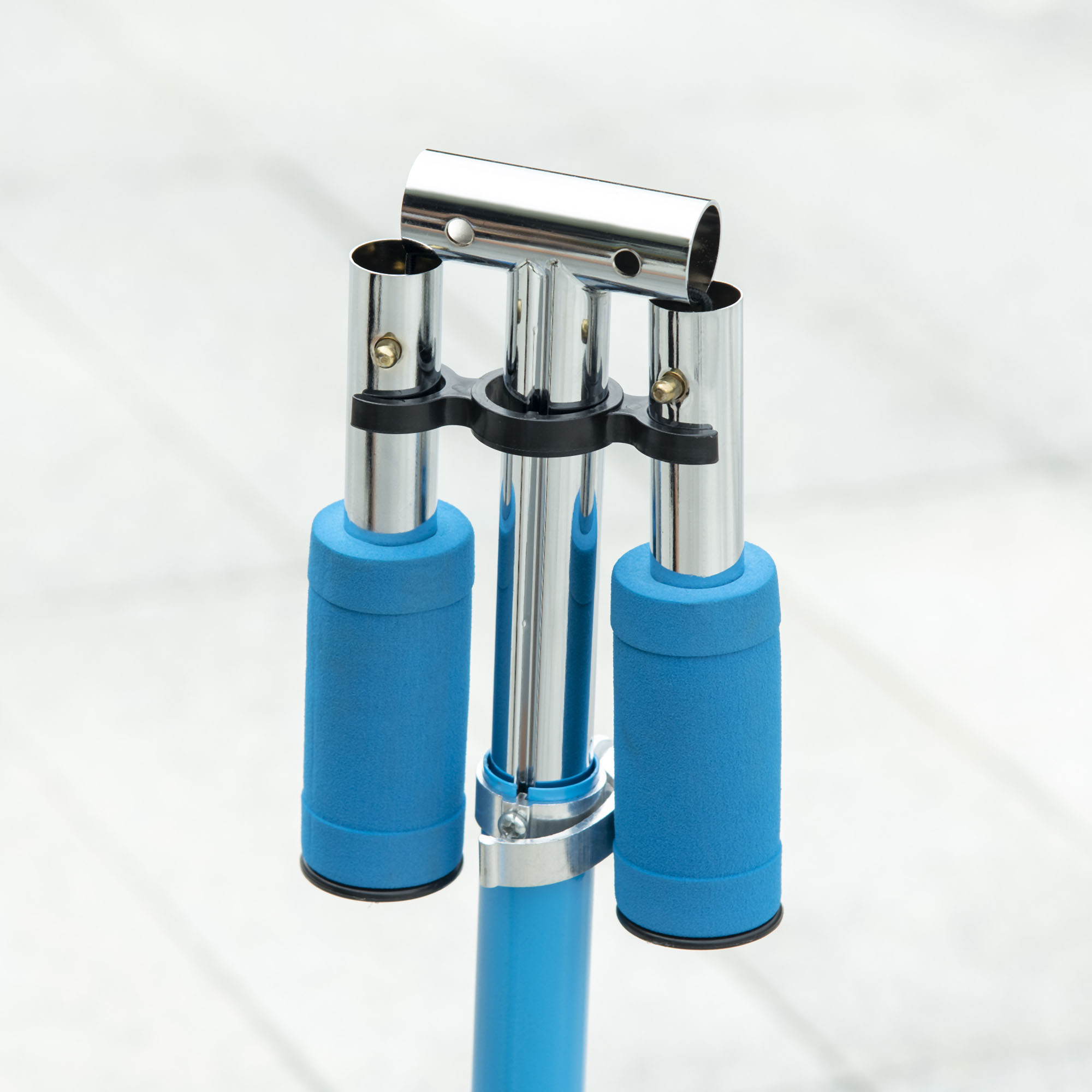 Manubrio dello scooter con impugnature blu e un elemento centrale argentato, cromato.