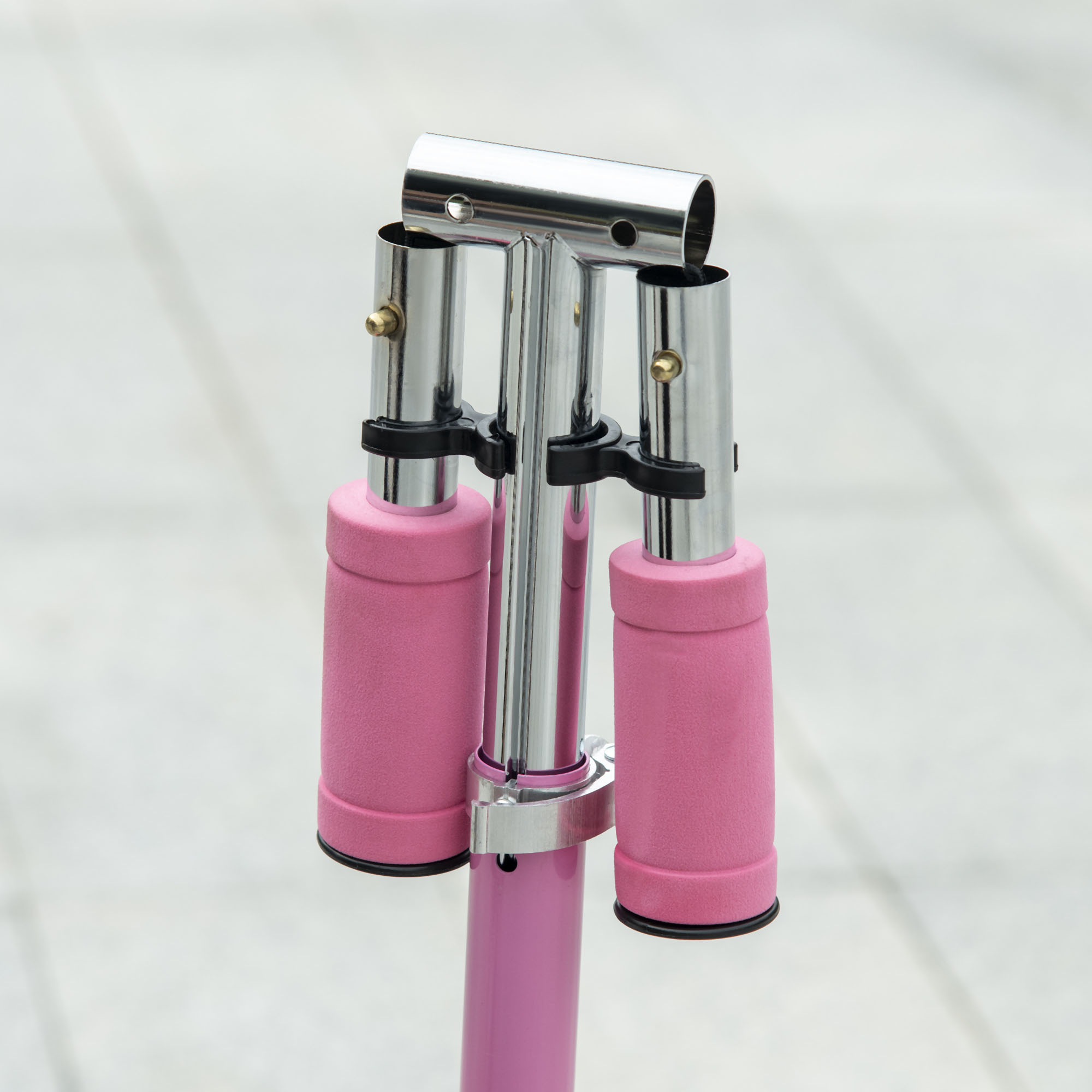 Un manubrio per scooter rosa con impugnature rosa e una barra centrale cromata.