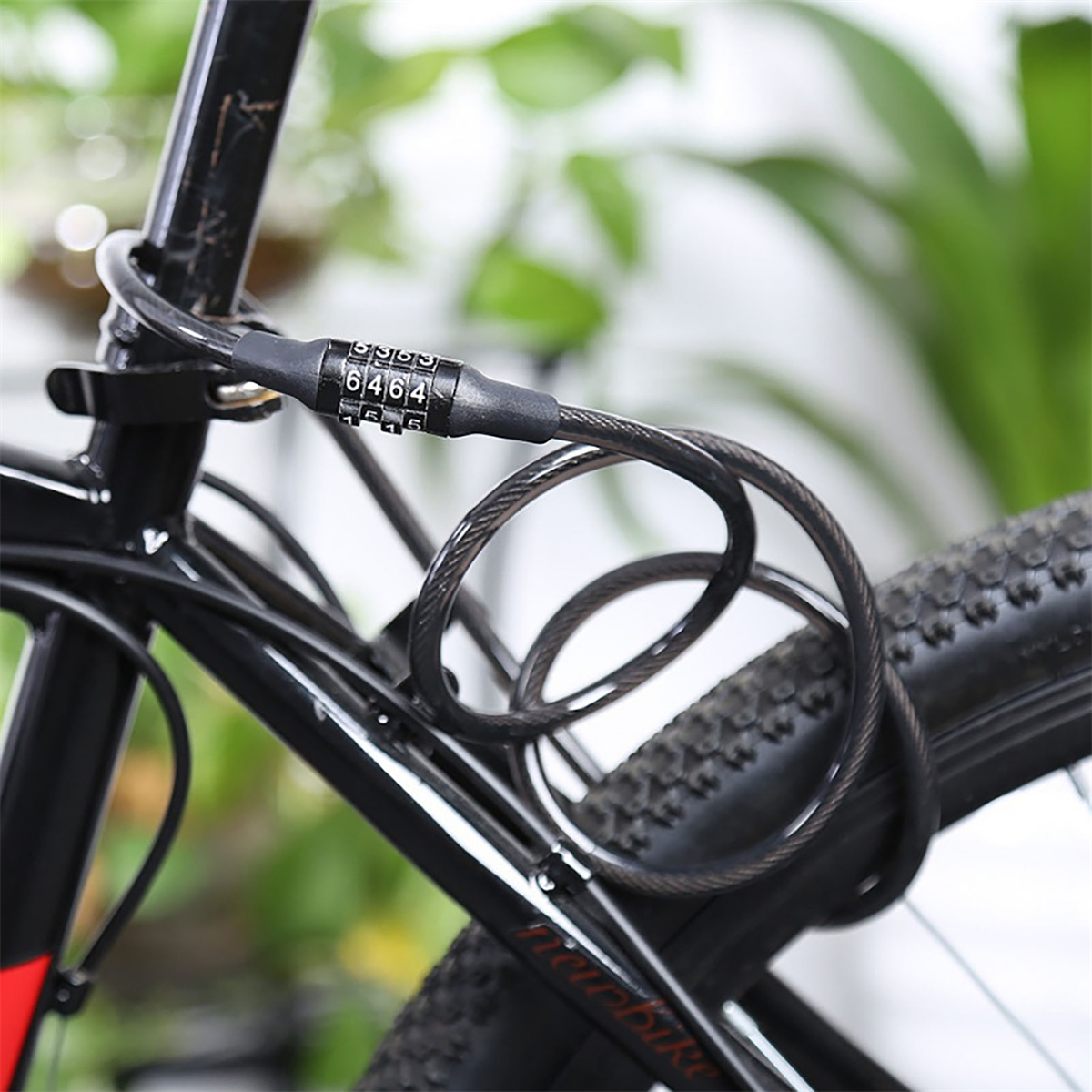 Schwarzes Fahrradkabelschloss am Fahrradrahmen befestigt. Die Zahlen 6464 sind auf dem Schloss sichtbar.