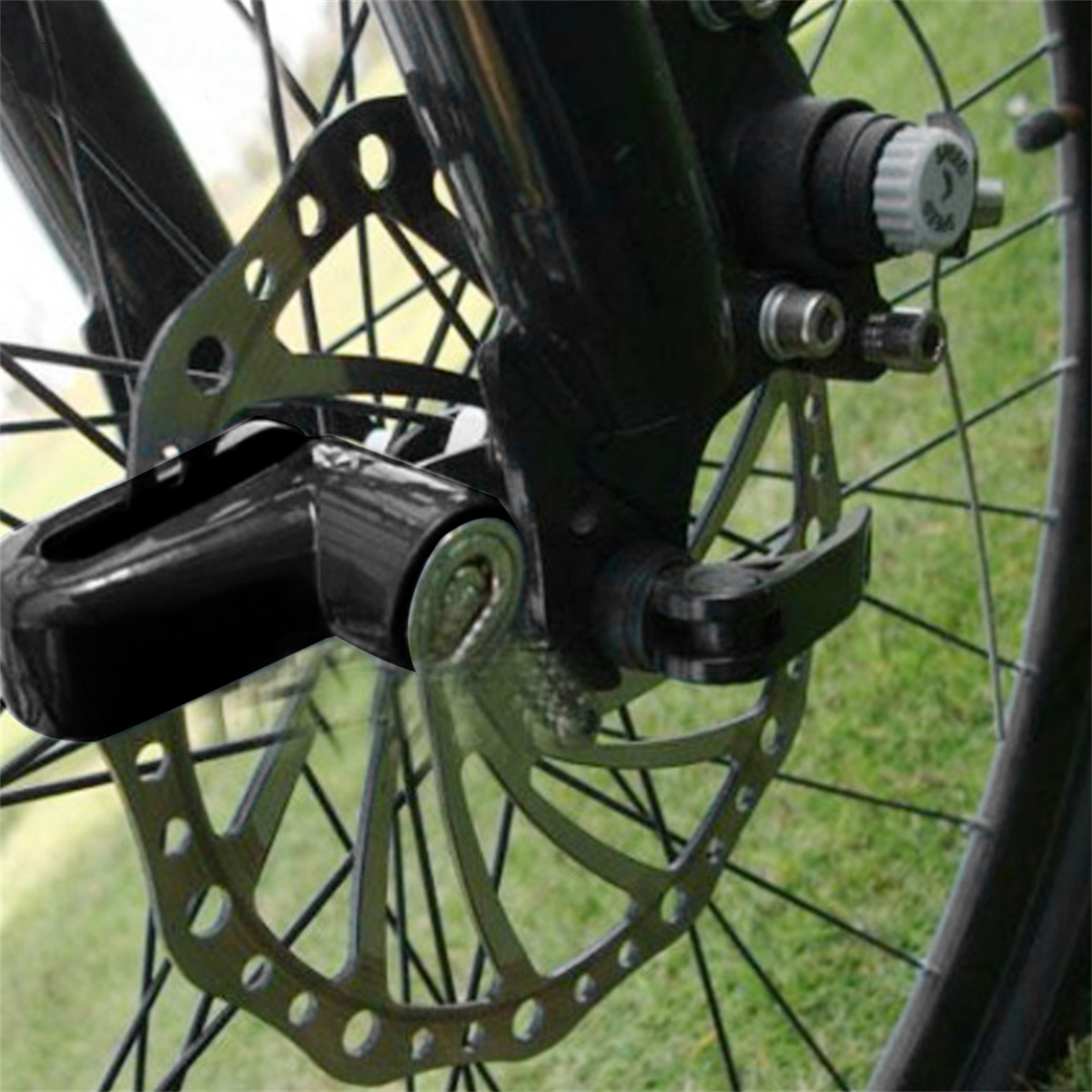 Schwarzes Fahrradschloss, das ein Fahrradrad verriegelt, mit silberner Bremsscheibe.