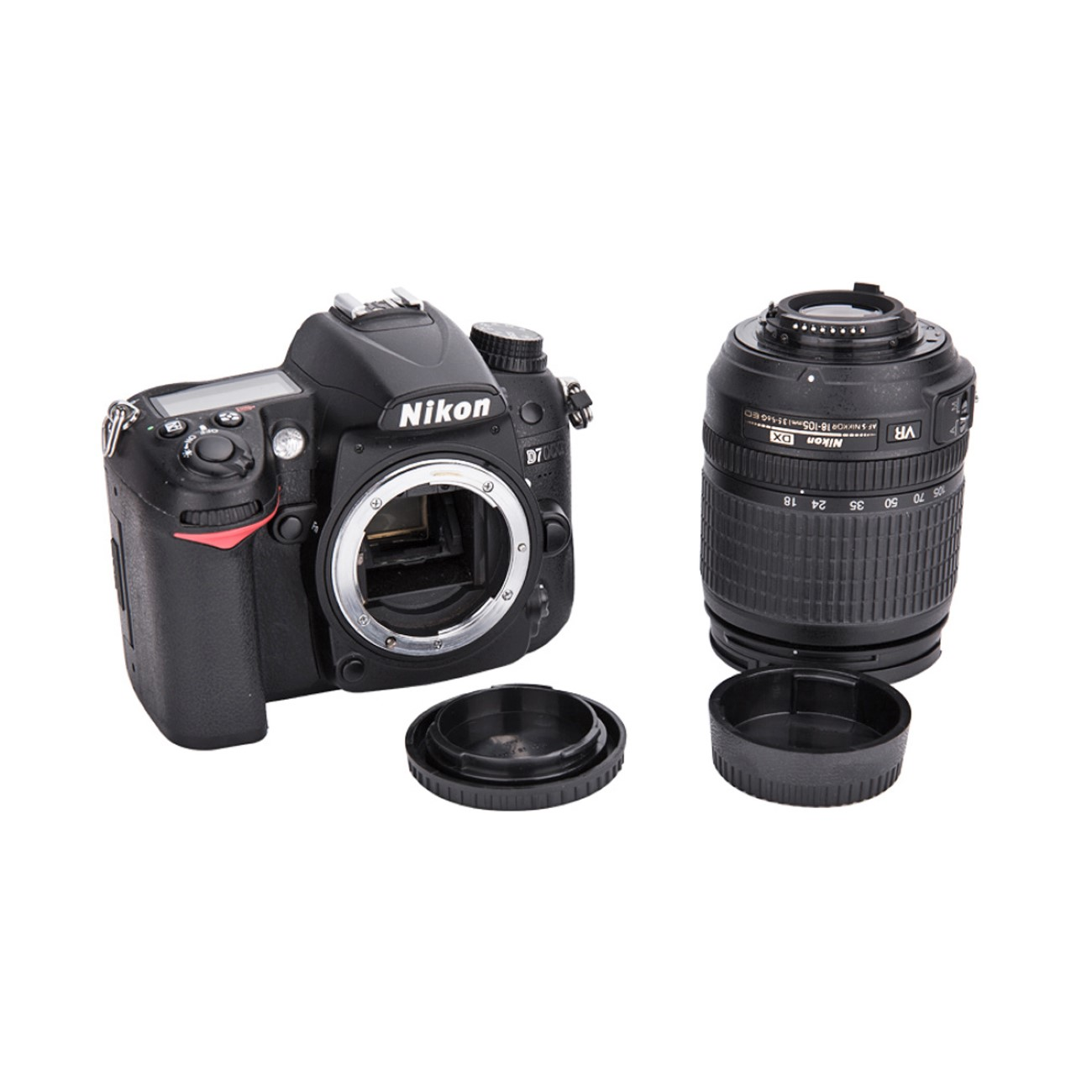 Schwarze Nikon D7000 DSLR-Kamera mit Objektiv und Objektivdeckel, vor weißem Hintergrund.