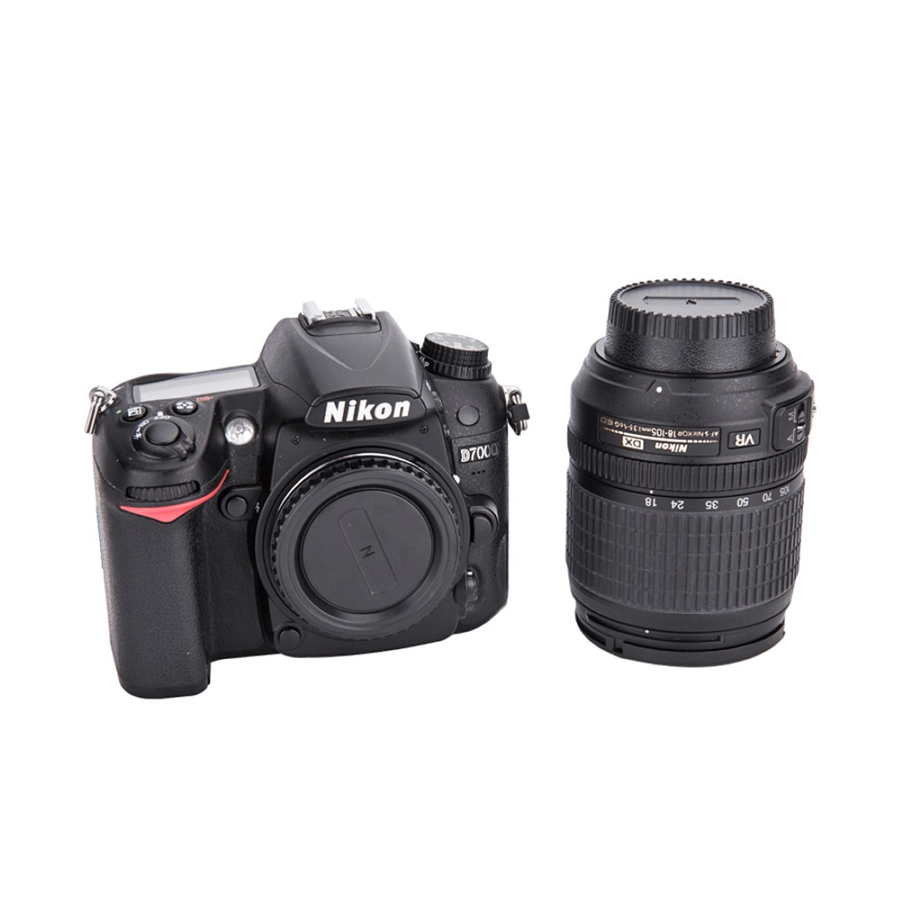 Schwarze Nikon D7000 Kamera mit Objektiv auf weißem Hintergrund. Das Objektiv liegt neben der Kamera.