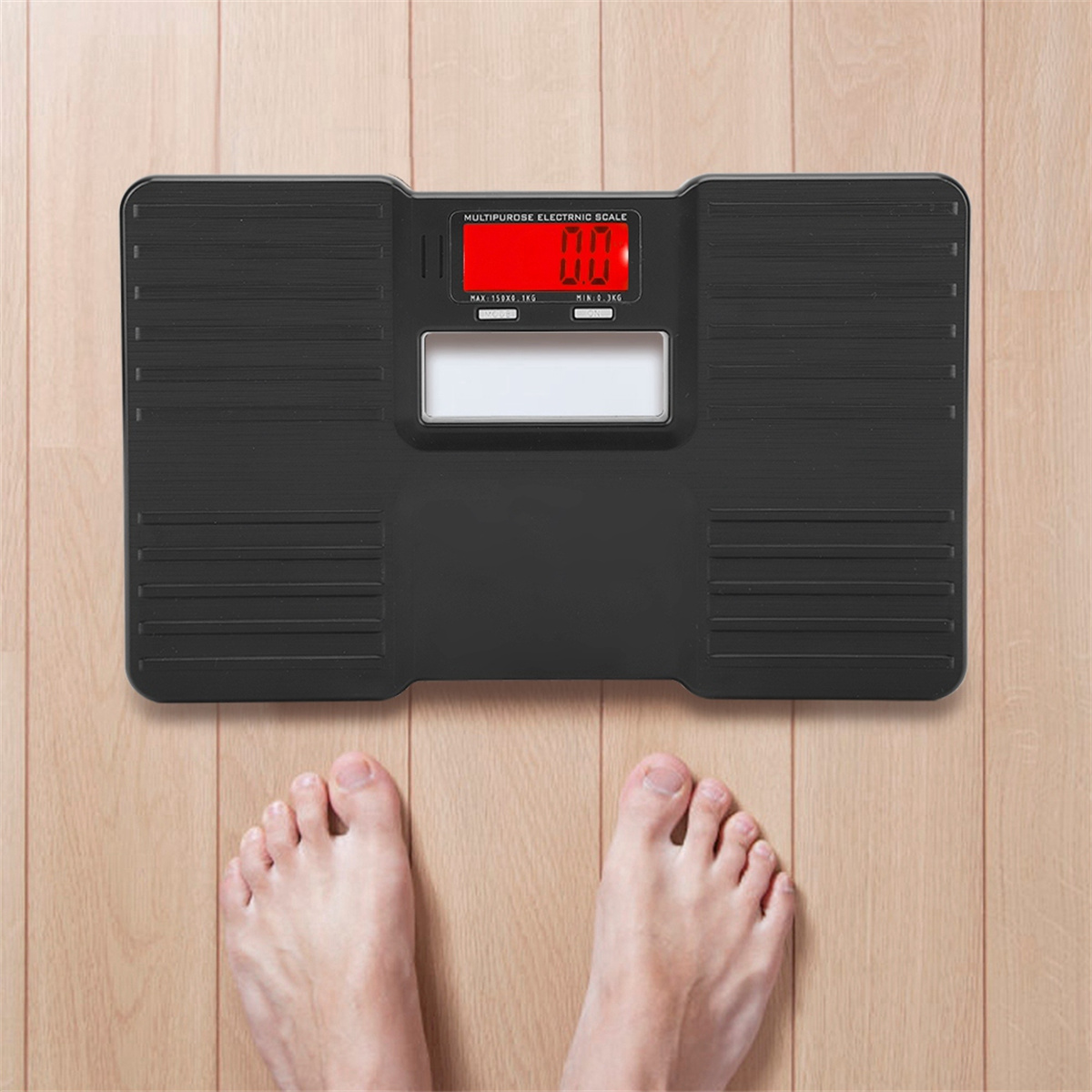 Eine schwarze Digitalwaage mit roter Anzeige, die 0,0 anzeigt. Die nackten Füße einer Person stehen auf dem Holzboden.