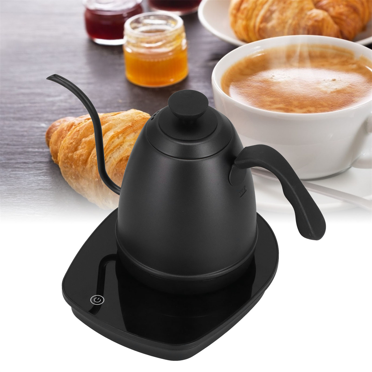 Schwarzer Schwanenhalskessel auf einer schwarzen Waage, mit Frühstücksartikeln wie Croissant und Kaffee.