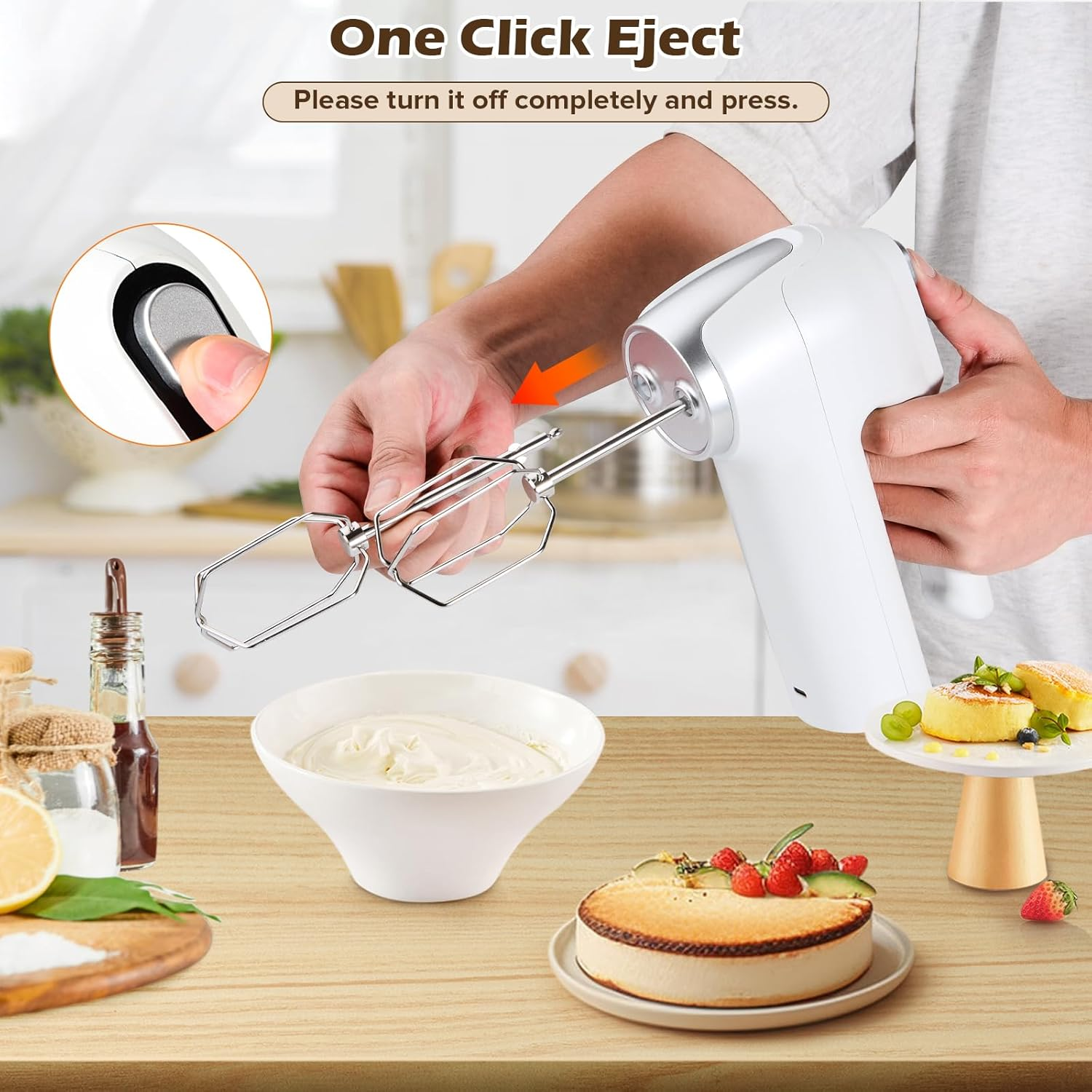 Ein Handmixer wirft Schneebesen aus. Ein Kuchen und eine Schüssel Sahne stehen auf einem Holztisch.