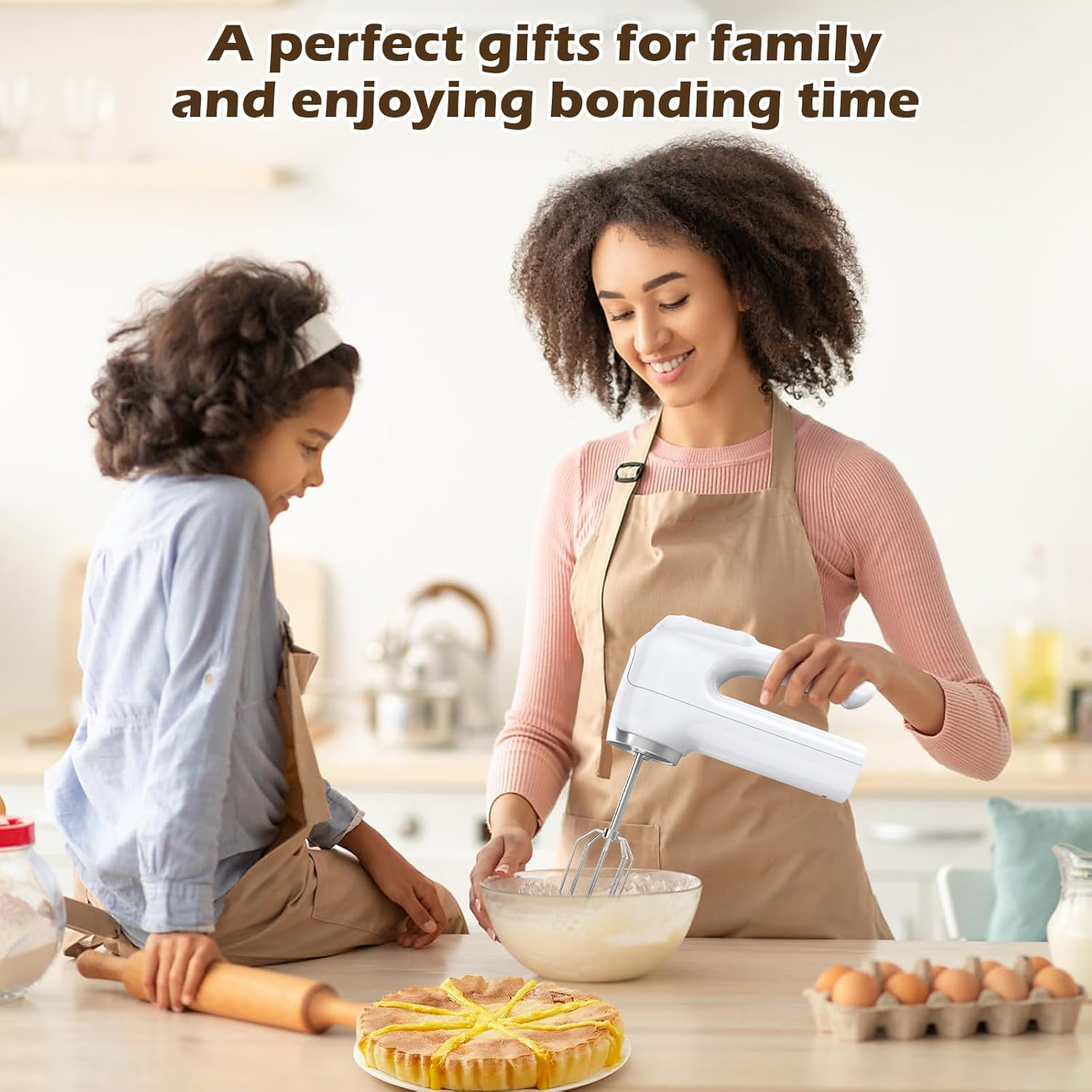 Mutter und Tochter backen Kuchen. Mutter benutzt einen Mixer, Tochter schaut zu. Kuchen und Zutaten stehen auf dem Tisch.