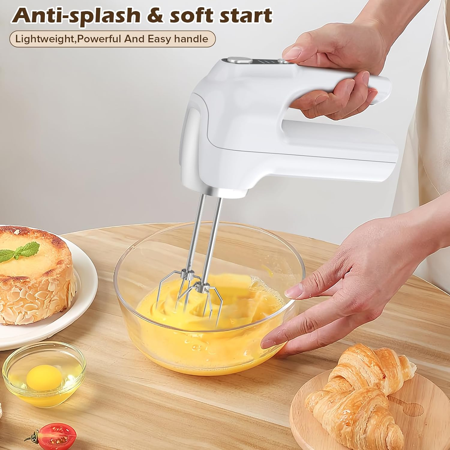 Weißer Handmixer, der Eier in einer Glasschüssel verrührt.