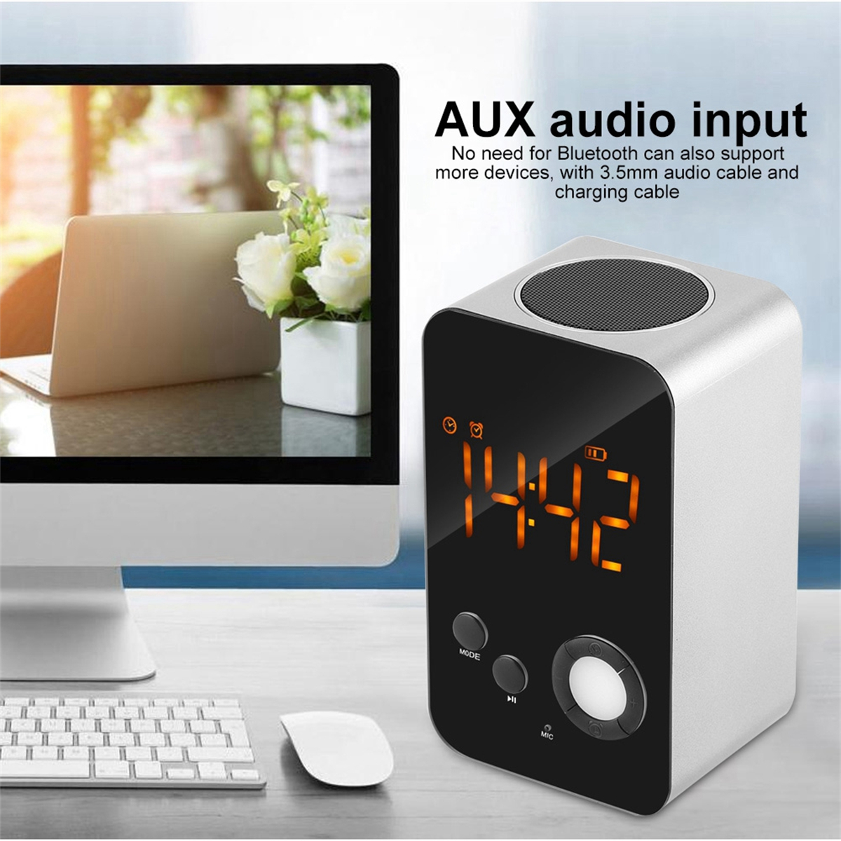 Digitaler Wecker mit der Anzeige 14:42, mit Computer und Blumen im Hintergrund.