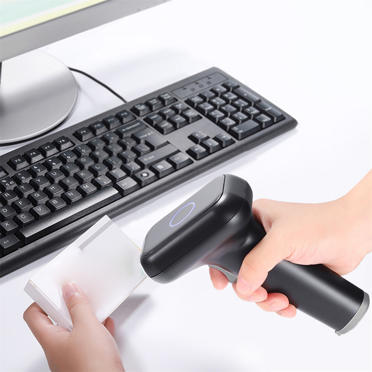 Eine Hand, die einen Barcode-Scanner über einem Stapel weißem Papier hält.