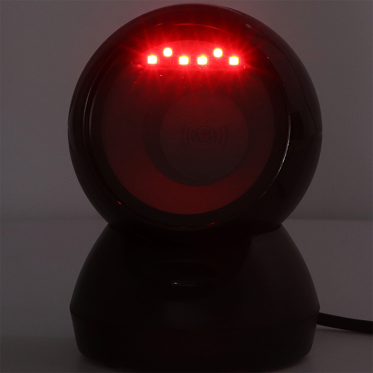 Ein dunkler Scanner mit rotem Licht oben strahlt ein rotes Leuchten aus.