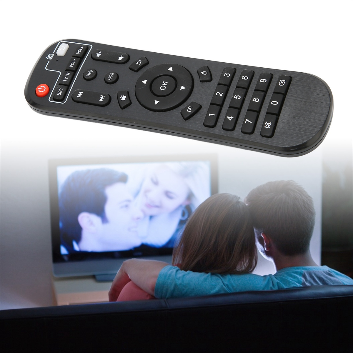 Schwarze TV-Fernbedienung mit mehreren Knöpfen, vor einem Fernsehbildschirm.