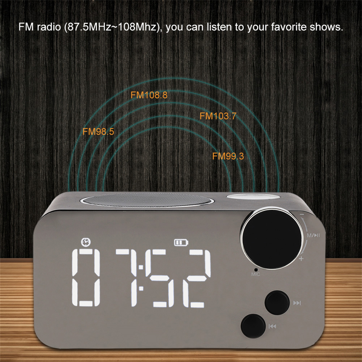 Graues digitales Radiowecker mit schwarzem Knopf und Display. Zeigt Uhrzeit und Radiofrequenzen.