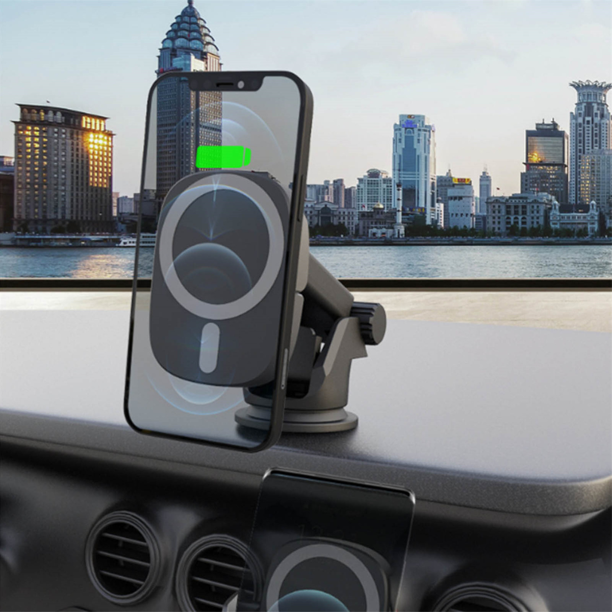 Ein schwarzes Telefon ist auf dem Armaturenbrett eines Autos montiert. Das Telefon lädt drahtlos und eine Stadt ist im Hintergrund.