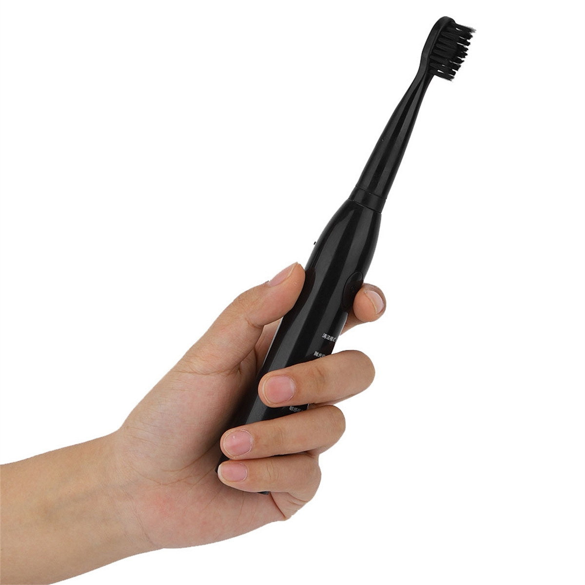 Eine schwarze elektrische Zahnbürste. Sie wird in einer Hand gehalten, die Bürste zeigt nach oben.