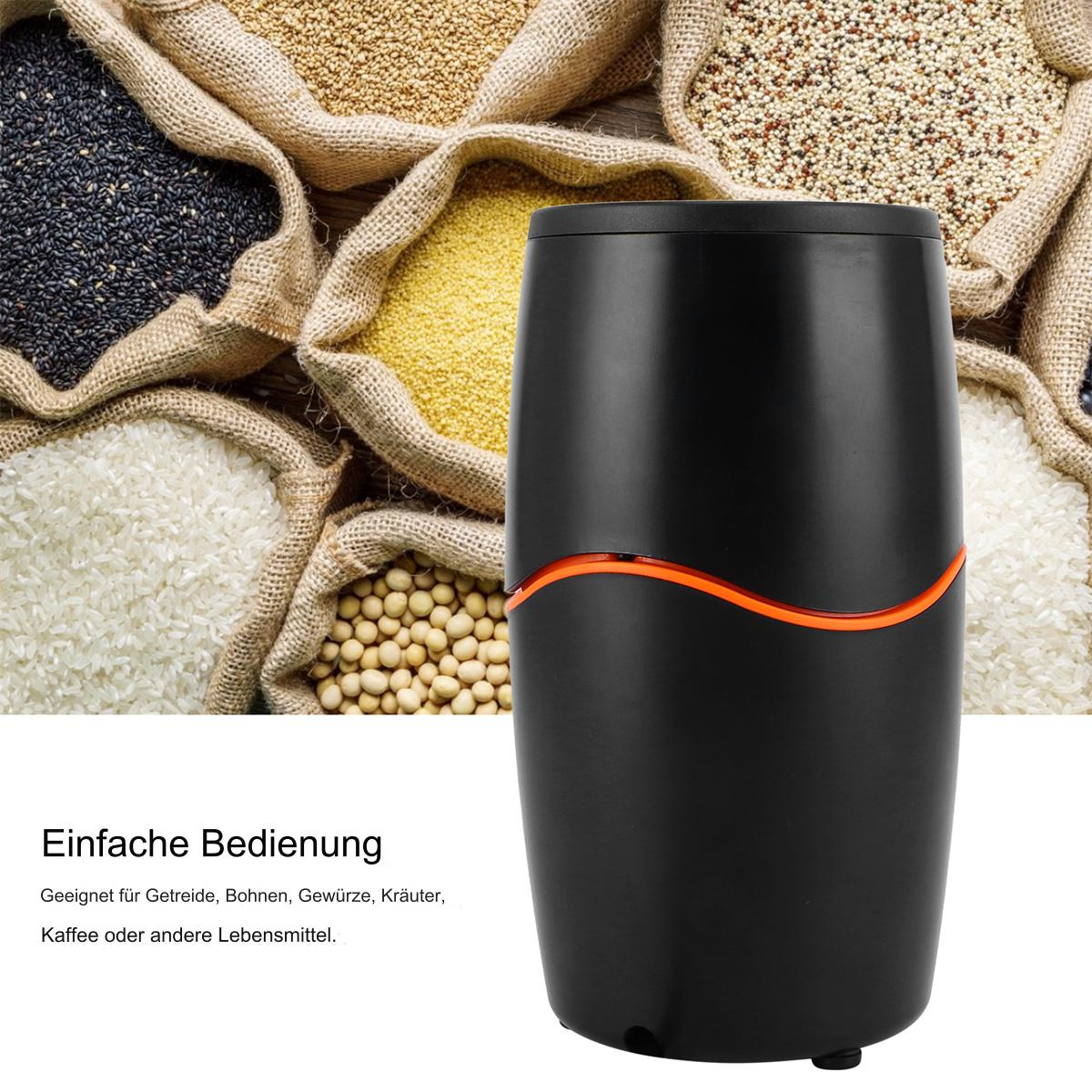 Schwarze Kaffeemühle mit orangefarbenem Lichtband und Jutesäcken mit Getreide im Hintergrund.
