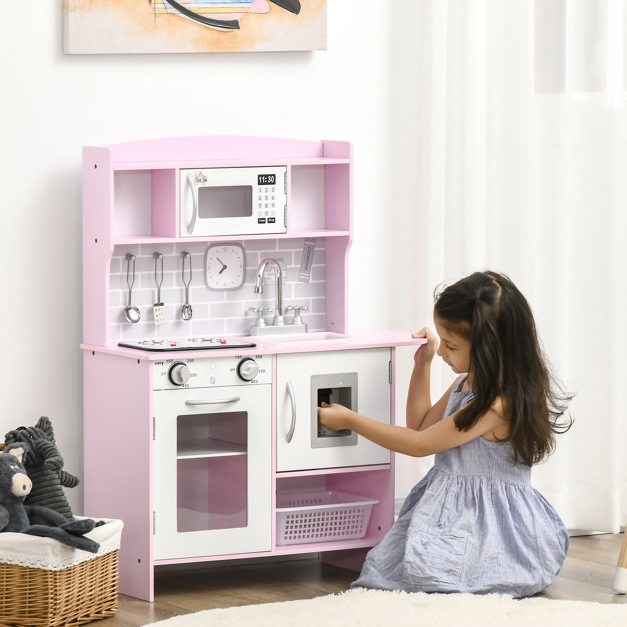 Niña jugando con una cocina de juguete rosa en un entorno doméstico.