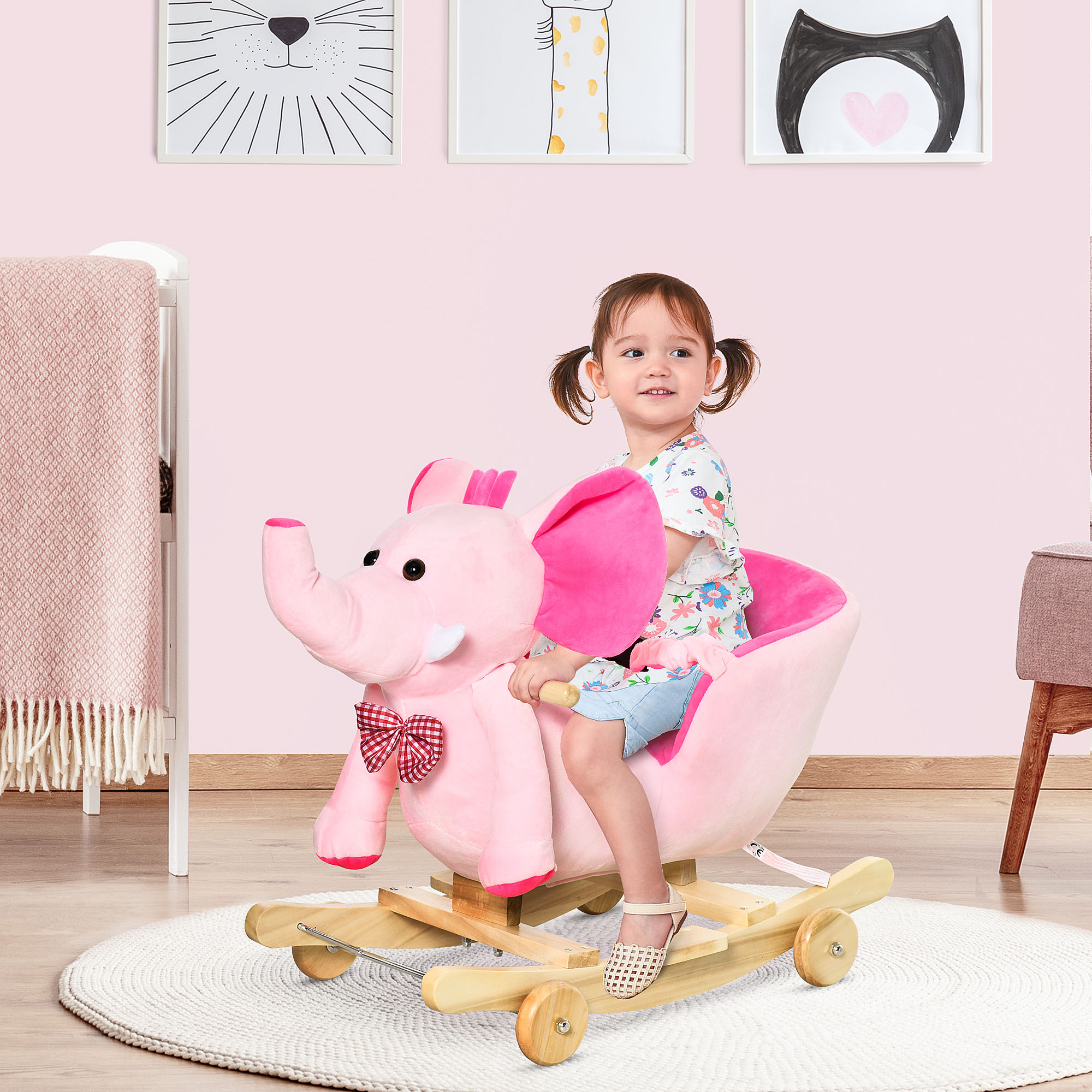 Niña en un caballito balancín de elefante rosa. Habitación rosa con cuna y manta rosa.