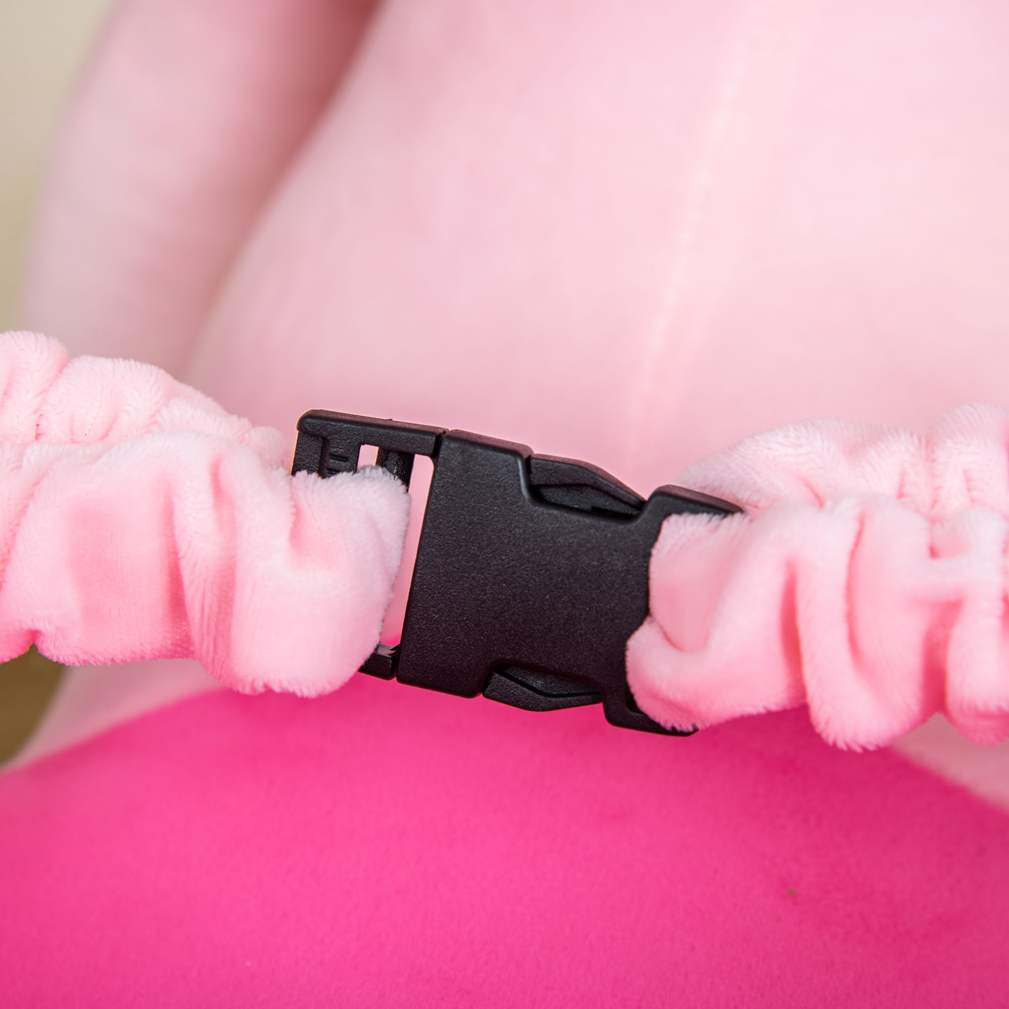Se muestra un primer plano de una correa elástica rosa con una hebilla negra.