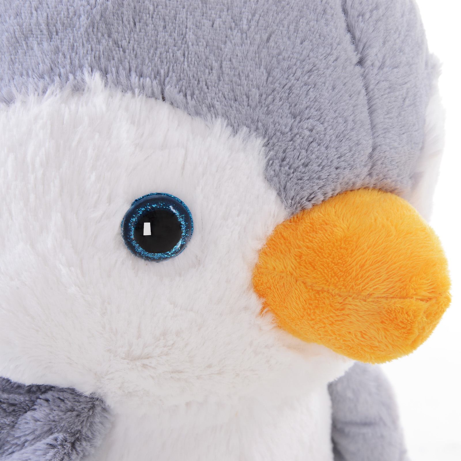 Un primo piano di un peluche a forma di pinguino, con testa grigia, viso bianco e becco arancione. Un occhio blu è visibile.