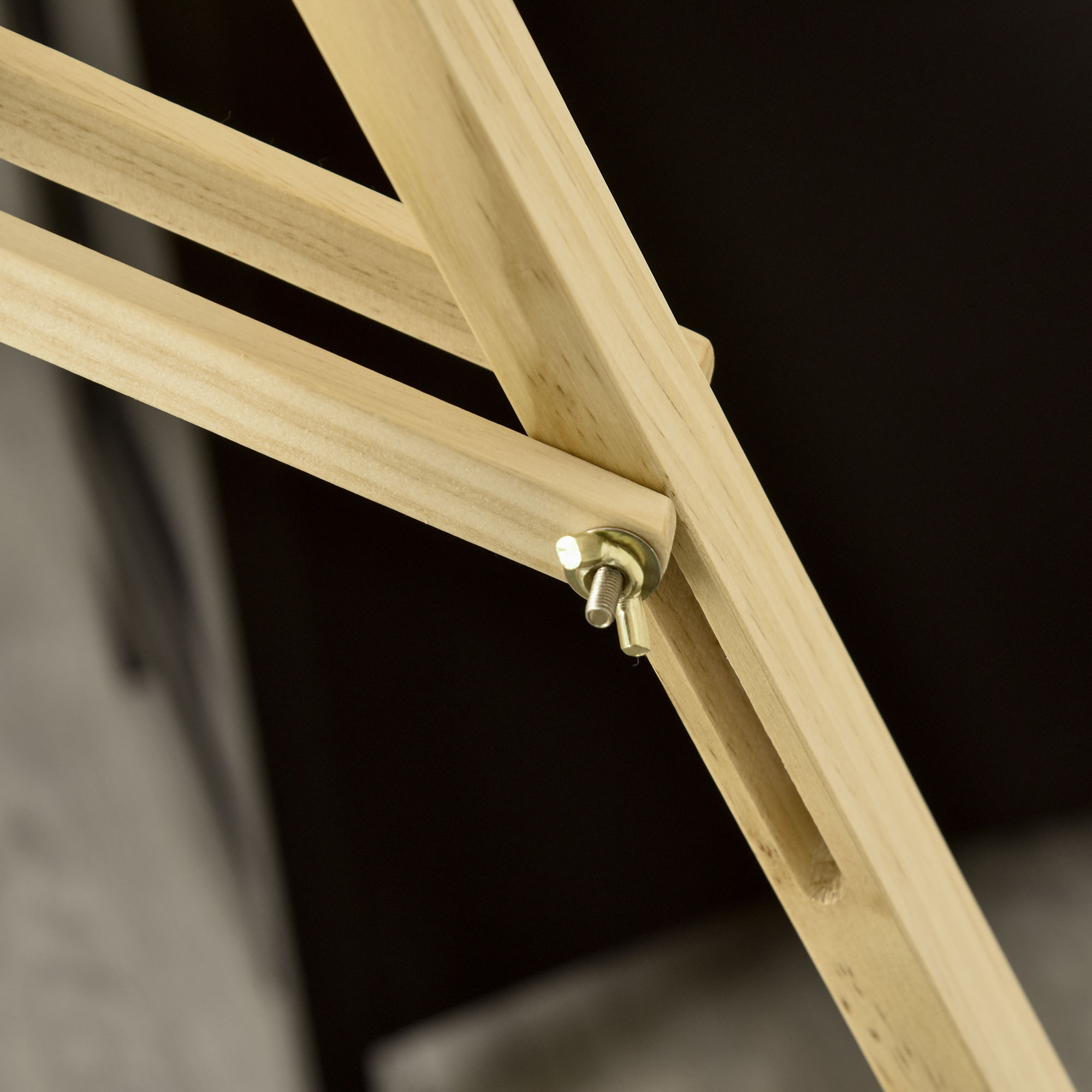 Primer plano de una unión de marco de madera. Un perno y una tuerca aseguran las piezas de madera. La madera tiene un color natural.