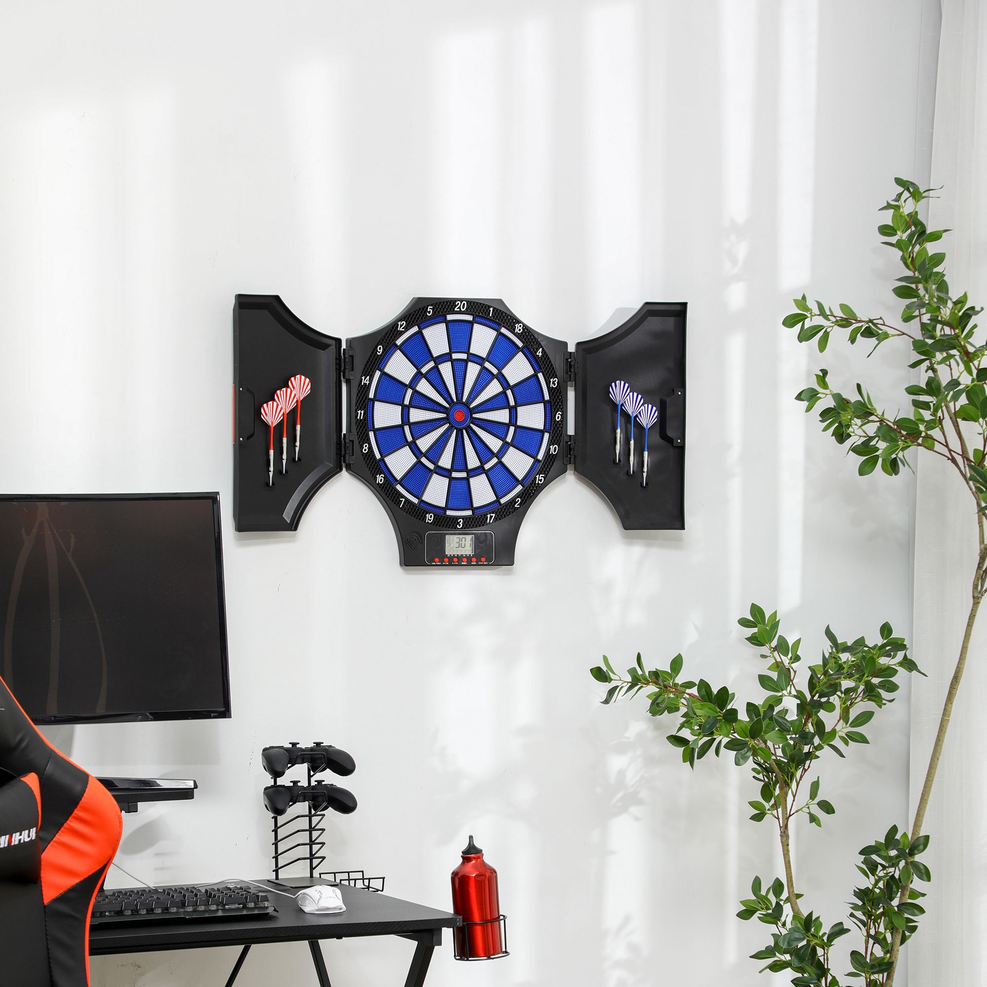 Dartscheibe mit Darts, umgeben von Schreibtisch, Computer und grüner Pflanze.