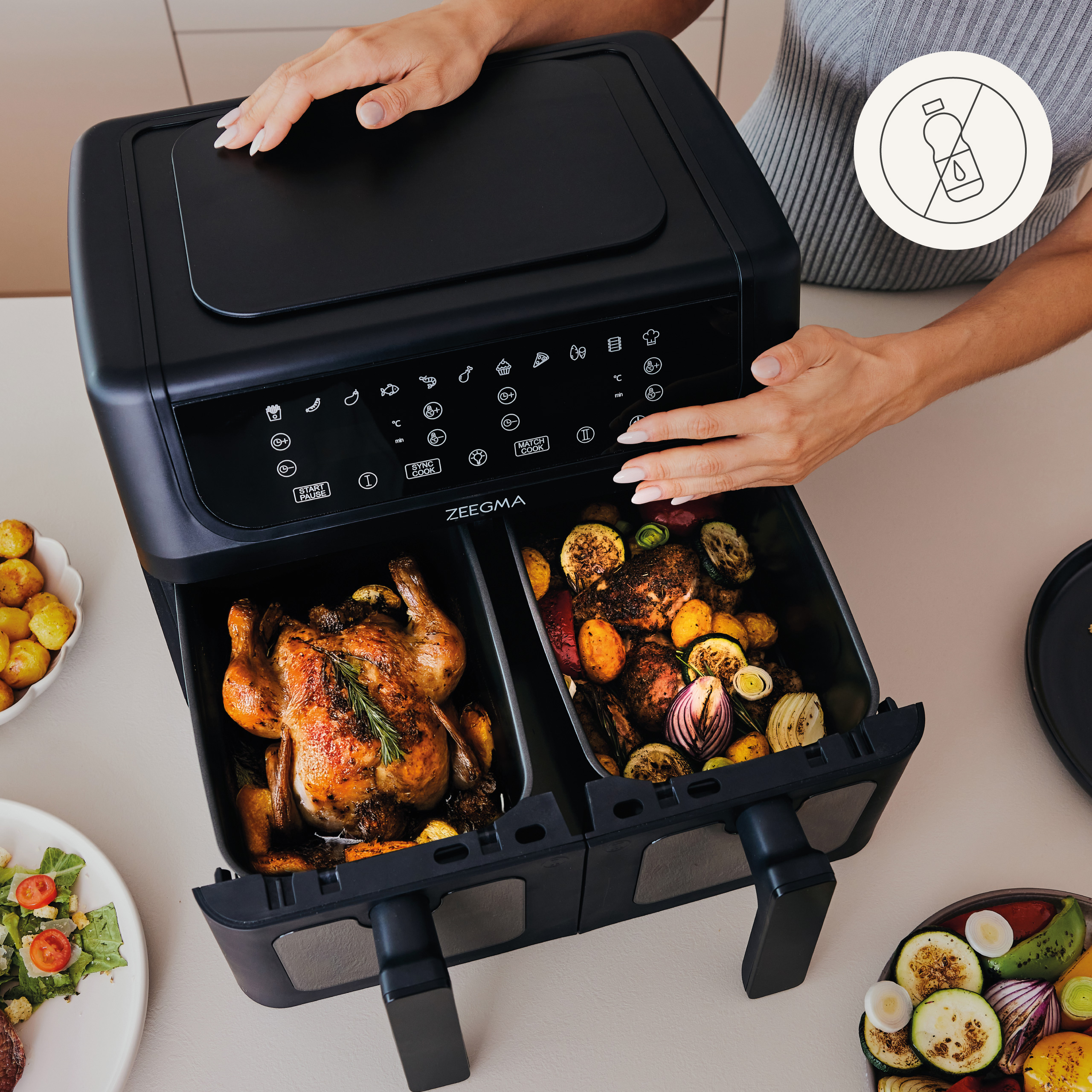 Czarna frytkownica powietrzna z dwiema komorami zawierającymi ugotowane jedzenie.