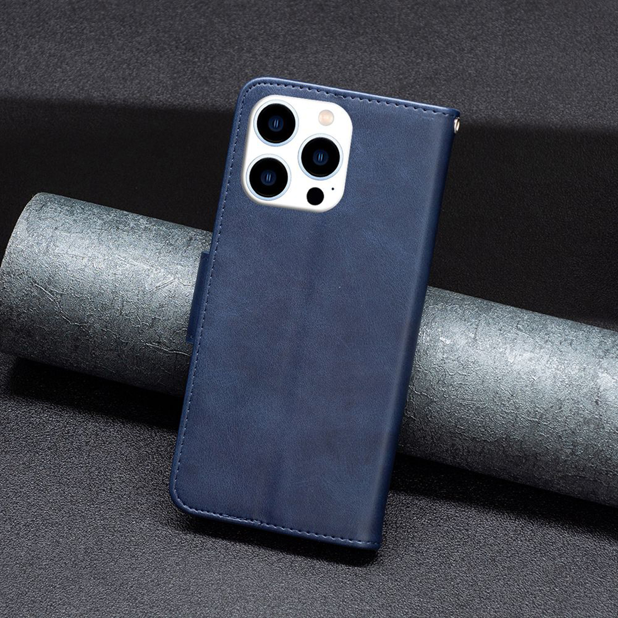 Coque de téléphone bleue sur une surface sombre. La coque est fermée. Elle a une découpe pour la caméra et des fentes pour cartes.