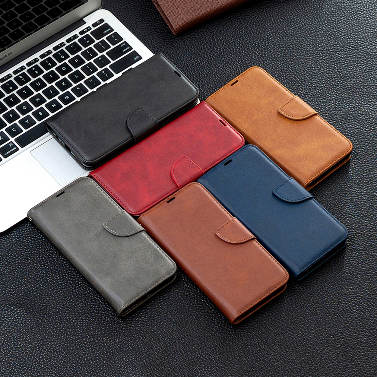 Meerdere gekleurde telefoonhoesjes: zwart, rood, bruin, grijs, blauw en bruin, gerangschikt op een donker oppervlak.